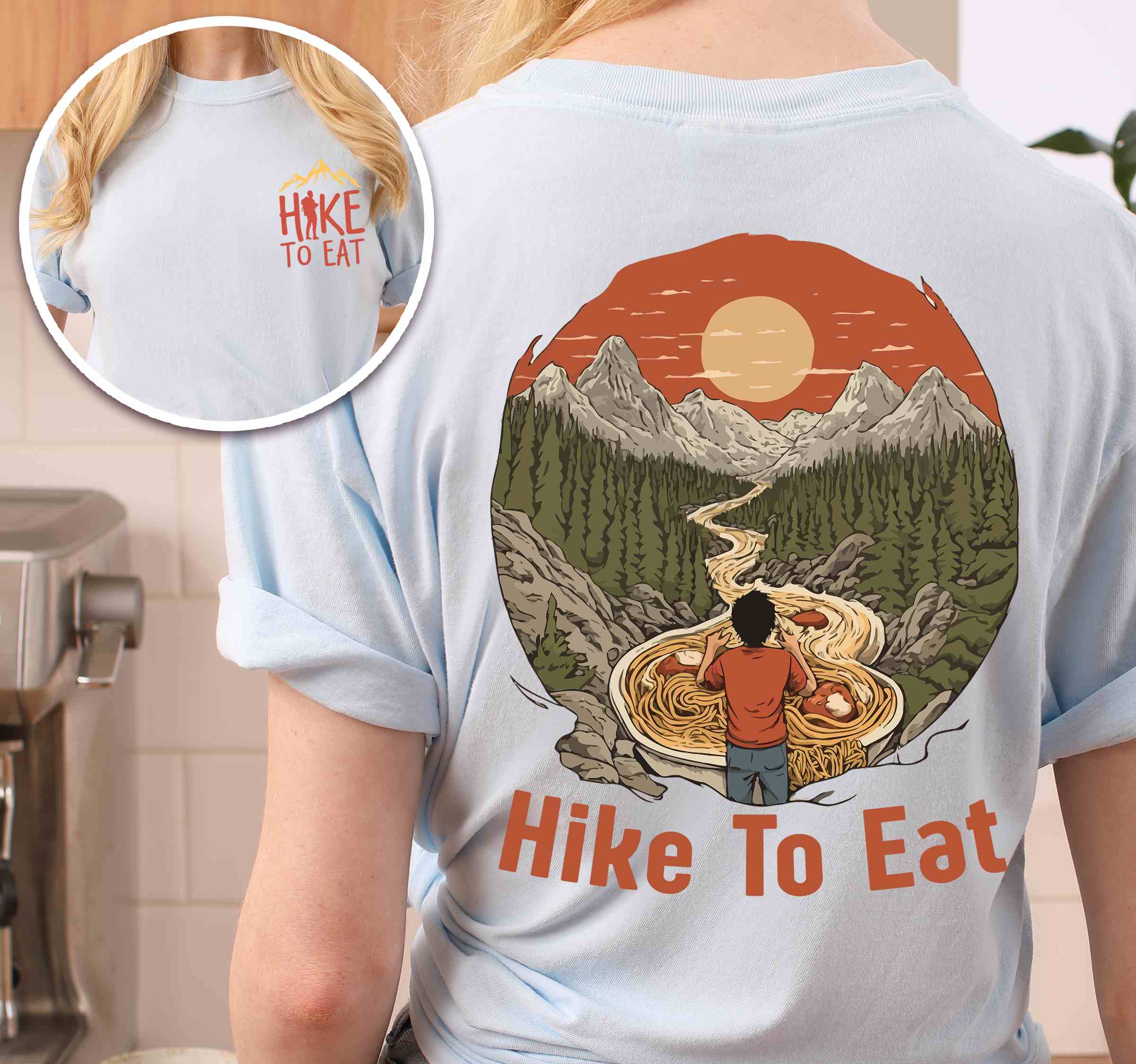 Woman wearing chambray "Hike to Eat" text in bold lettering back design, mountains, birds, illustrated ramen noodles, and backpacker perfect for ramen enthusiasts.