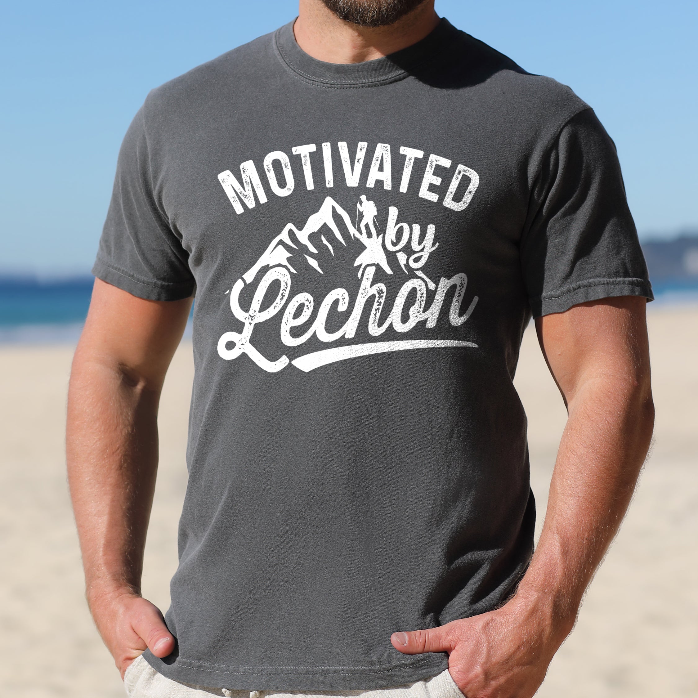 Pepper (Dark Gray) graphic t-shirt with 'Motivated by Lechon' text in white lettering featuring mountain silhouettes and hiker illustration