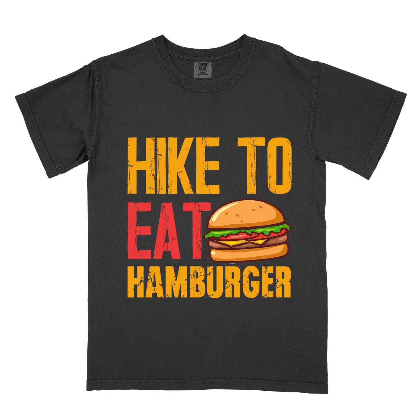 Black t-shirt with distressed text reading "HIKE TO EAT HAMBURGER" arranged in three lines. "HIKE TO" appears in yellow at the top, "EAT" in red in the middle with a colorful hamburger illustration next to it, and "HAMBURGER" in yellow at the bottom. The hamburger graphic shows a bun, meat patty, cheese, lettuce, and tomato.