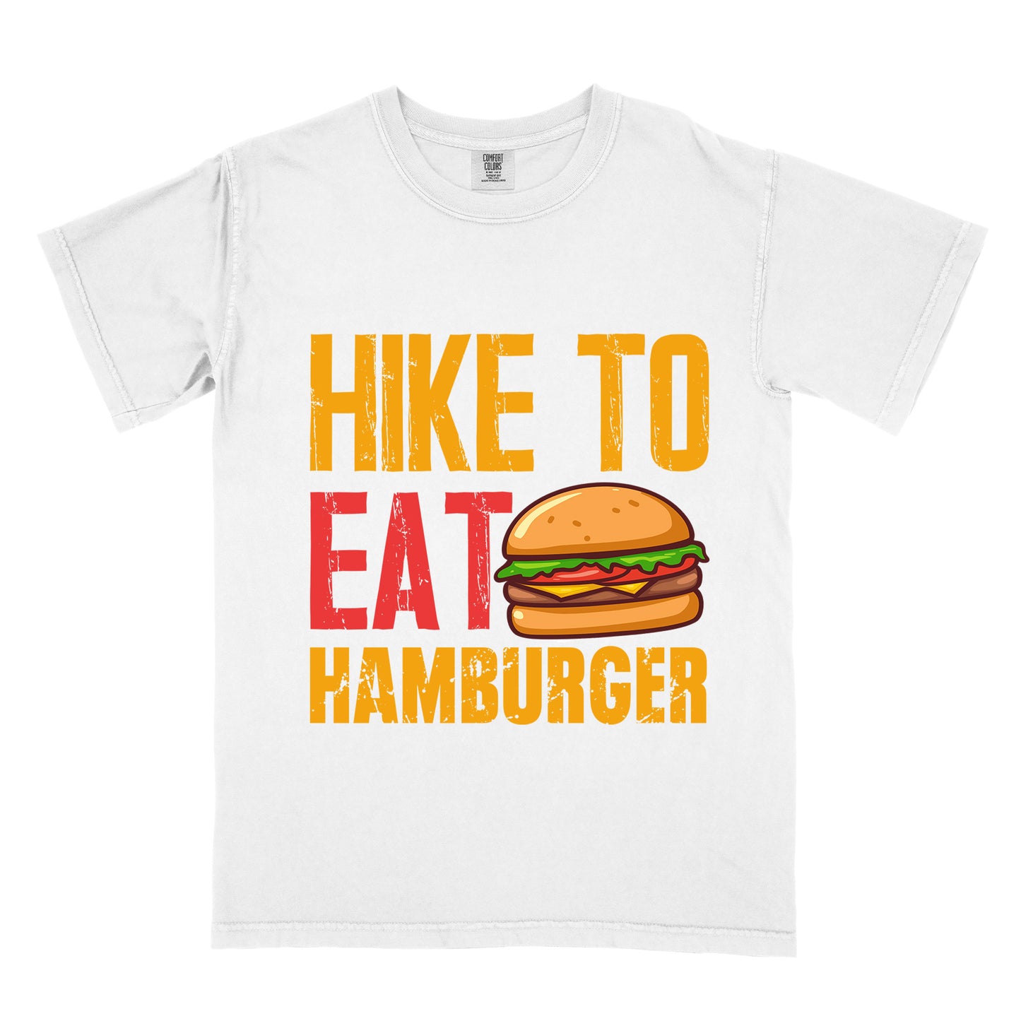 White t-shirt with distressed text reading "HIKE TO EAT HAMBURGER" arranged in three lines. "HIKE TO" appears in yellow at the top, "EAT" in red in the middle with a colorful hamburger illustration next to it, and "HAMBURGER" in yellow at the bottom. The hamburger graphic shows a bun, meat patty, cheese, lettuce, and tomato.