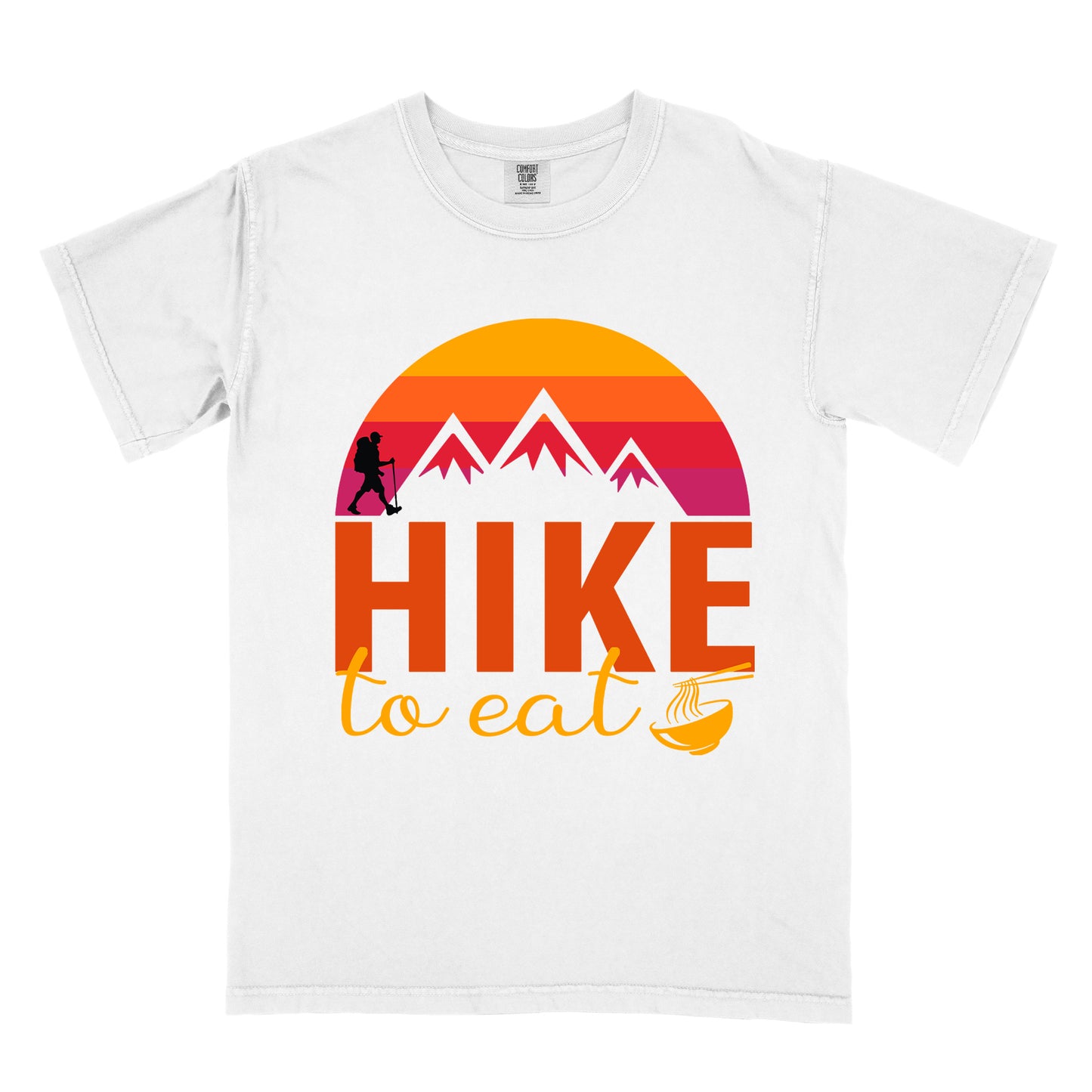 White t-shirt featuring a retro sunset design with gradient colors from yellow to orange to red to purple. Mountain silhouettes and a small hiker figure appear against the sunset. Below this is "HIKE" in large orange letters and "to eat" in yellow script, followed by a small illustration of a noodle bowl with chopsticks. The design has a vintage outdoor aesthetic.