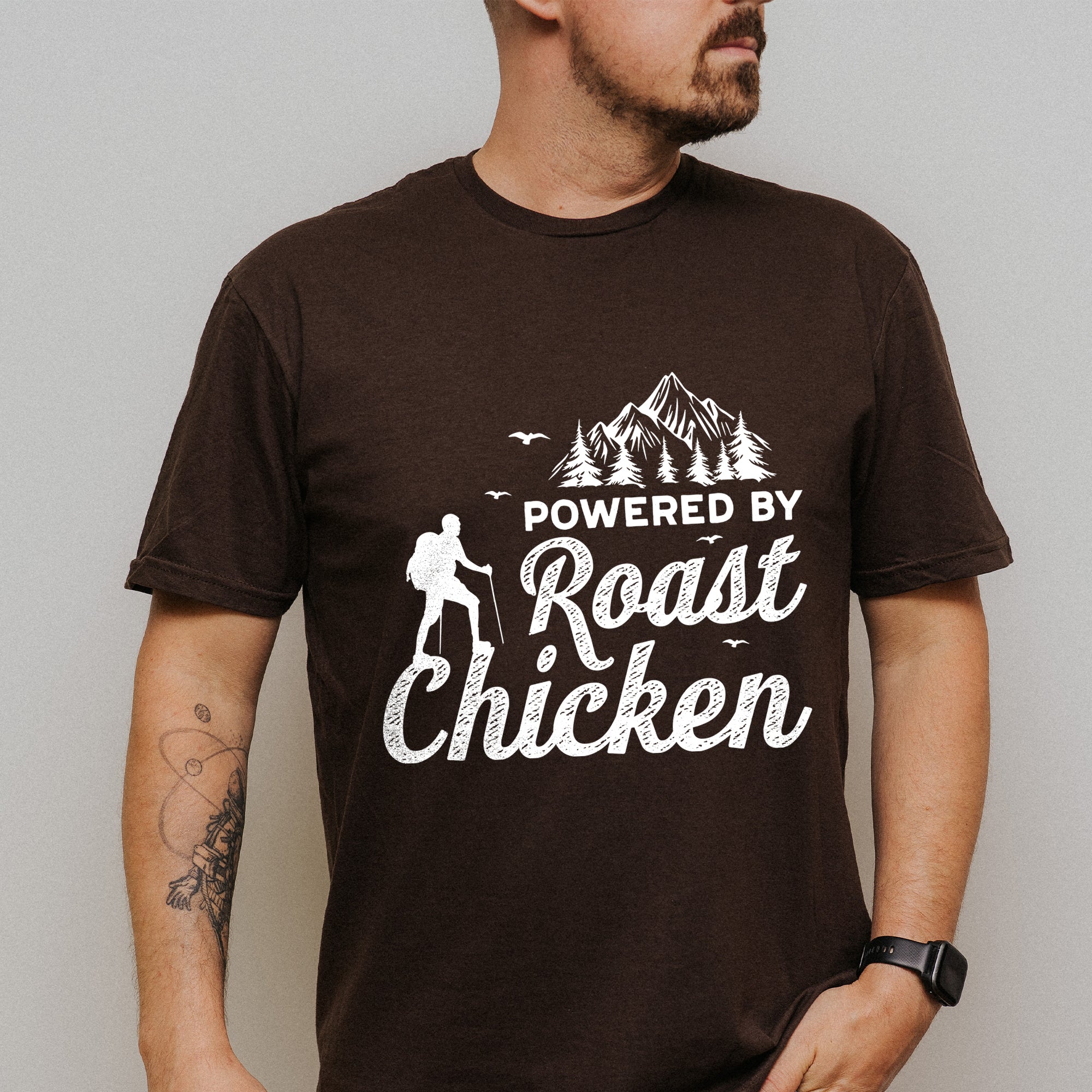 Person wearing a brown t-shirt with 'Powered by Roast Chicken' graphic design.
