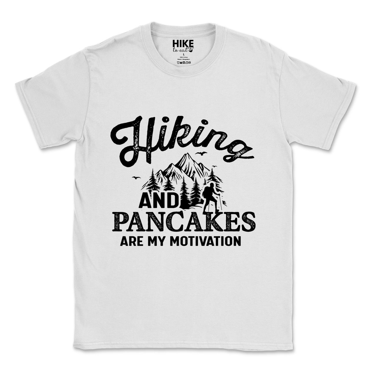 White Hiking and Pancakes are my motivation statement tee with flowing script typography, bold lettering, mountain peaks, pine trees, hiker silhouette, and flying birds for pancake-loving outdoor enthusiasts, hikers and foodies