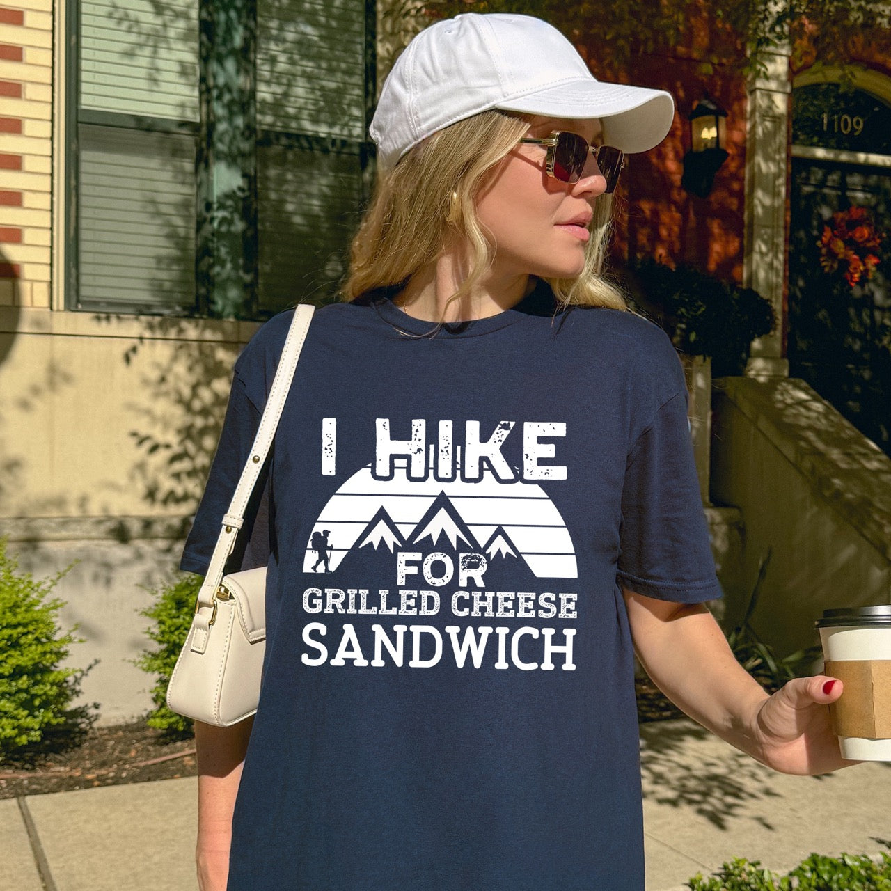 Woman wearing Navy I Hike for Grilled cheese Sandwich statement tee with bold distressed typography, geometric mountain design, and hiker silhouette for grilled cheese-loving outdoor enthusiasts, hikers and foodies