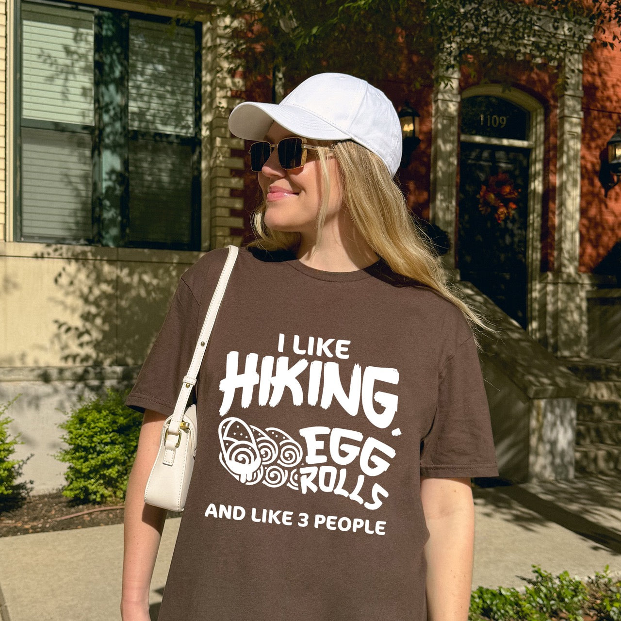 Man wearing Dark Chocolate Brown I like Hiking, Egg Rolls and like 3 People funny introvert statement tee with bold brushstroke typography and egg roll illustrations for Asian food-loving outdoor enthusiasts, hikers and foodies