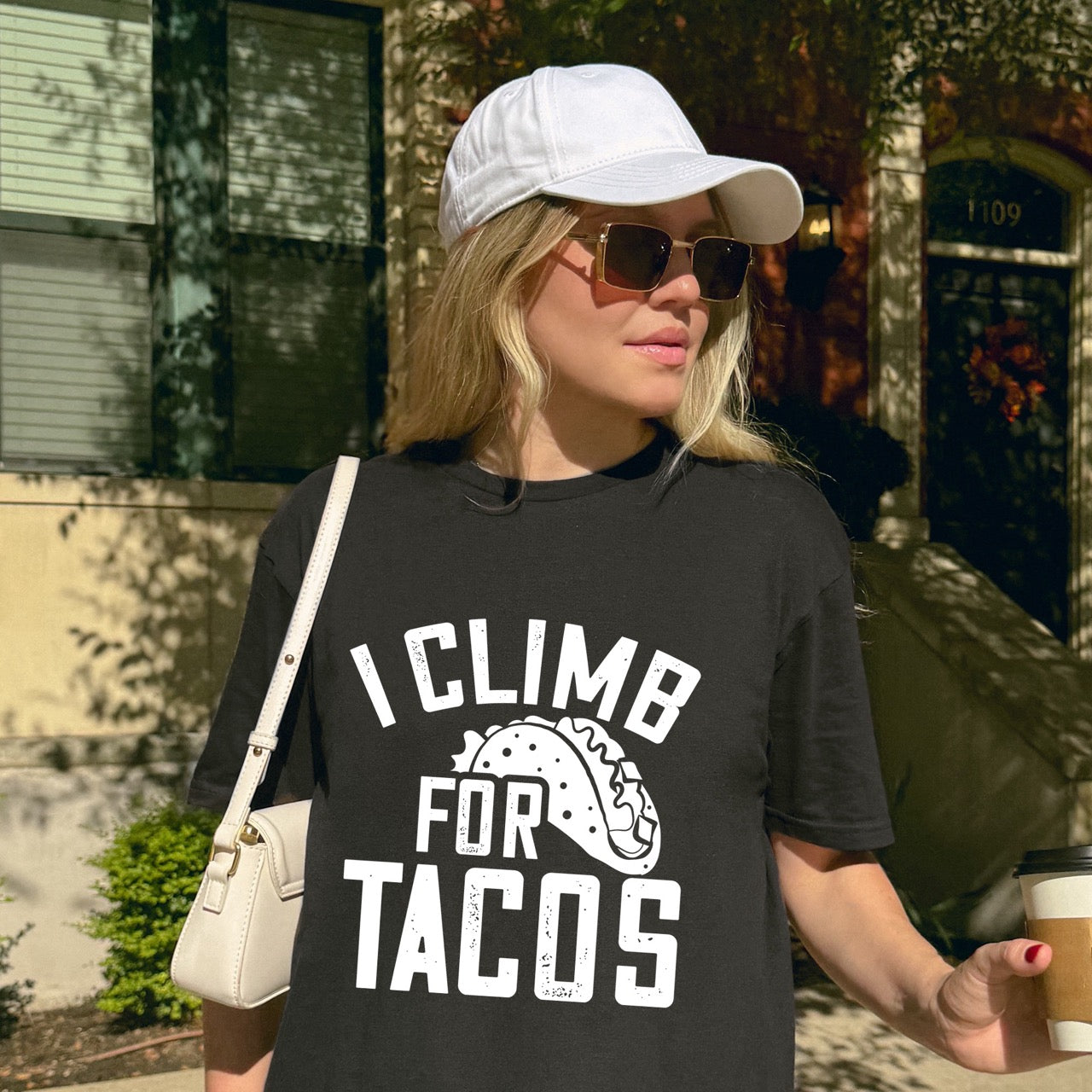 Woman wearing Black I climb for Tacos statement tee with bold distressed curved typography and detailed taco illustration for Mexican food-loving rock climbers and nature hikers.