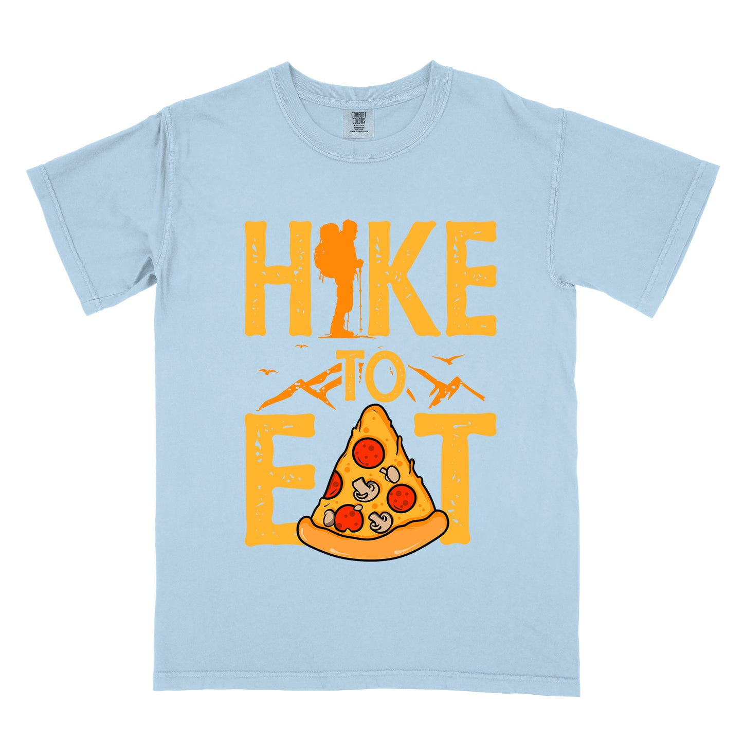A chambray(light blue) t-shirt featuring "HIKE TO EAT" in distressed orange-yellow lettering. The letter "I" in "HIKE" incorporates a silhouette of a hiker with a backpack. Below the words "TO" is an illustration of a pizza slice with pepperoni and mushroom toppings. Small mountain silhouettes appear under the word "TO" and also between the words "HIKE" and "EAT", with flying birds in the design.