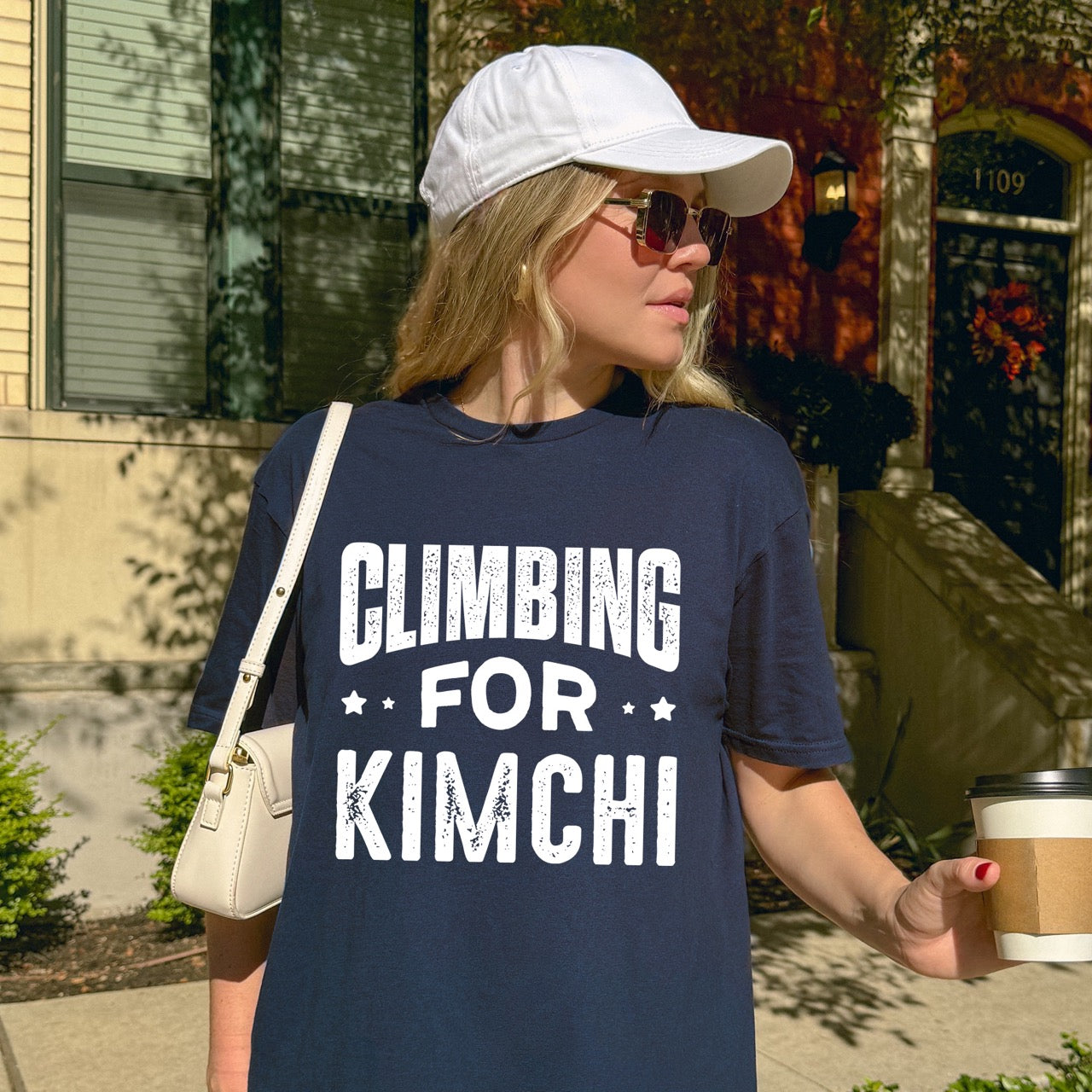 Woman wearing Navy Rock climbing enthusiast gift shirt Climbing For Kimchi with bold curved distressed typography and decorative star accents for Korean food lovers and outdoor athletes who crave fermented vegetables after mountain adventures for climbers, hikers and foodies