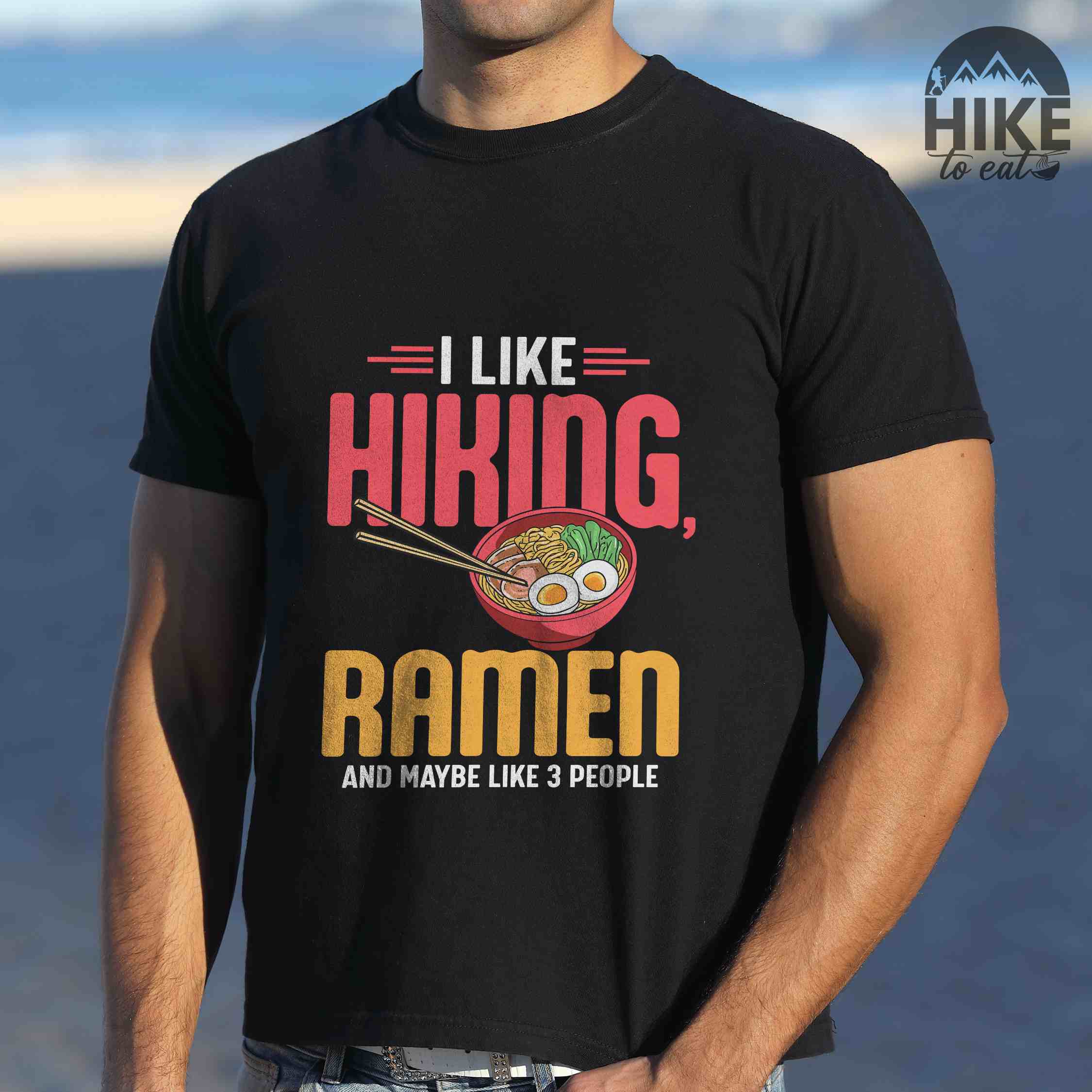 Man wearing black "I like Hiking, Ramen and maybe like three people" colored vintage tee with bold typography, and illustrated bowl of ramen for foodies
