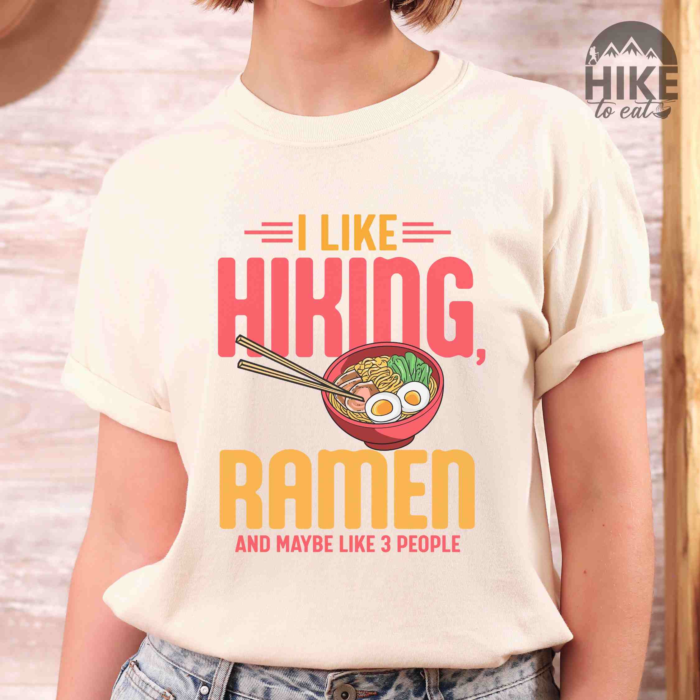 Woman wearing ivory "I like Hiking, Ramen and maybe like three people" colored vintage tee with bold typography, and illustrated bowl of ramen for foodies