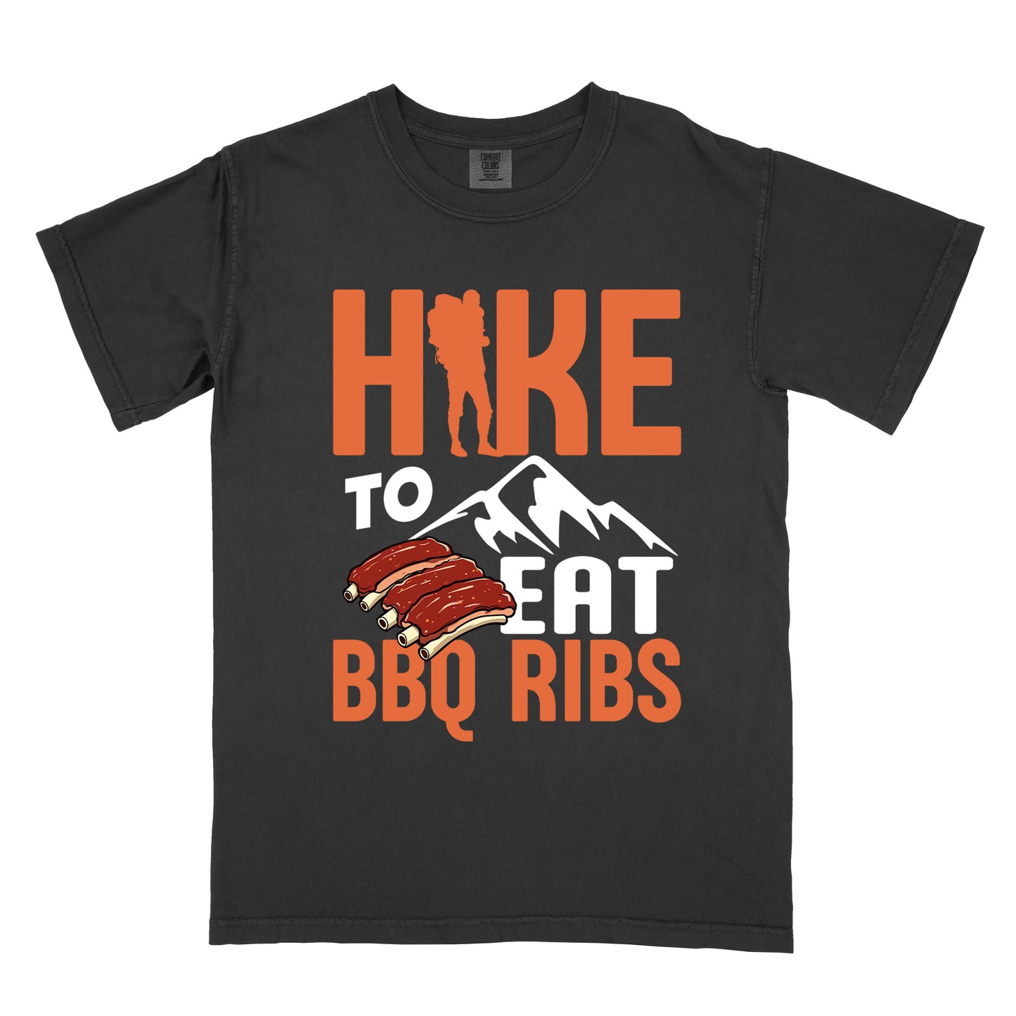 Black t-shirt with text "HIKE TO EAT BBQ RIBS". The word "HIKE" appears in orange with a hiker silhouette replacing the "I". Below that is "TO" in white text above a white mountain graphic. "EAT" appears in white, and "BBQ RIBS" in orange at the bottom. Between "EAT" and "BBQ RIBS" is an illustration of a rack of barbecue ribs with exposed bones.