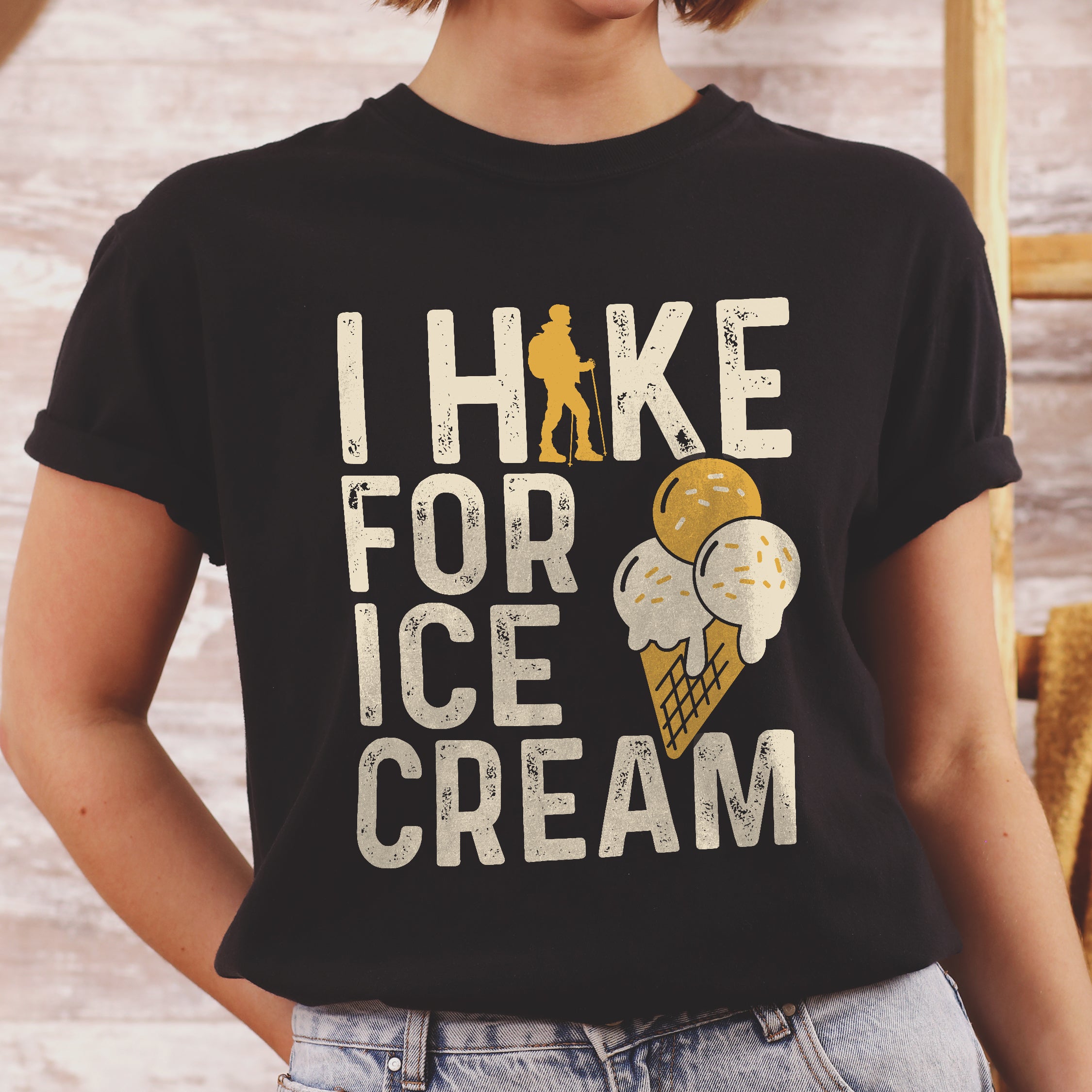woman wearing black I Hike for Ice Cream statement tee with vintage distressed typography, hiker silhouette, and double-scoop ice cream cone illustration on Comfort Colors shirt for dessert-loving outdoor enthusiasts and hikers