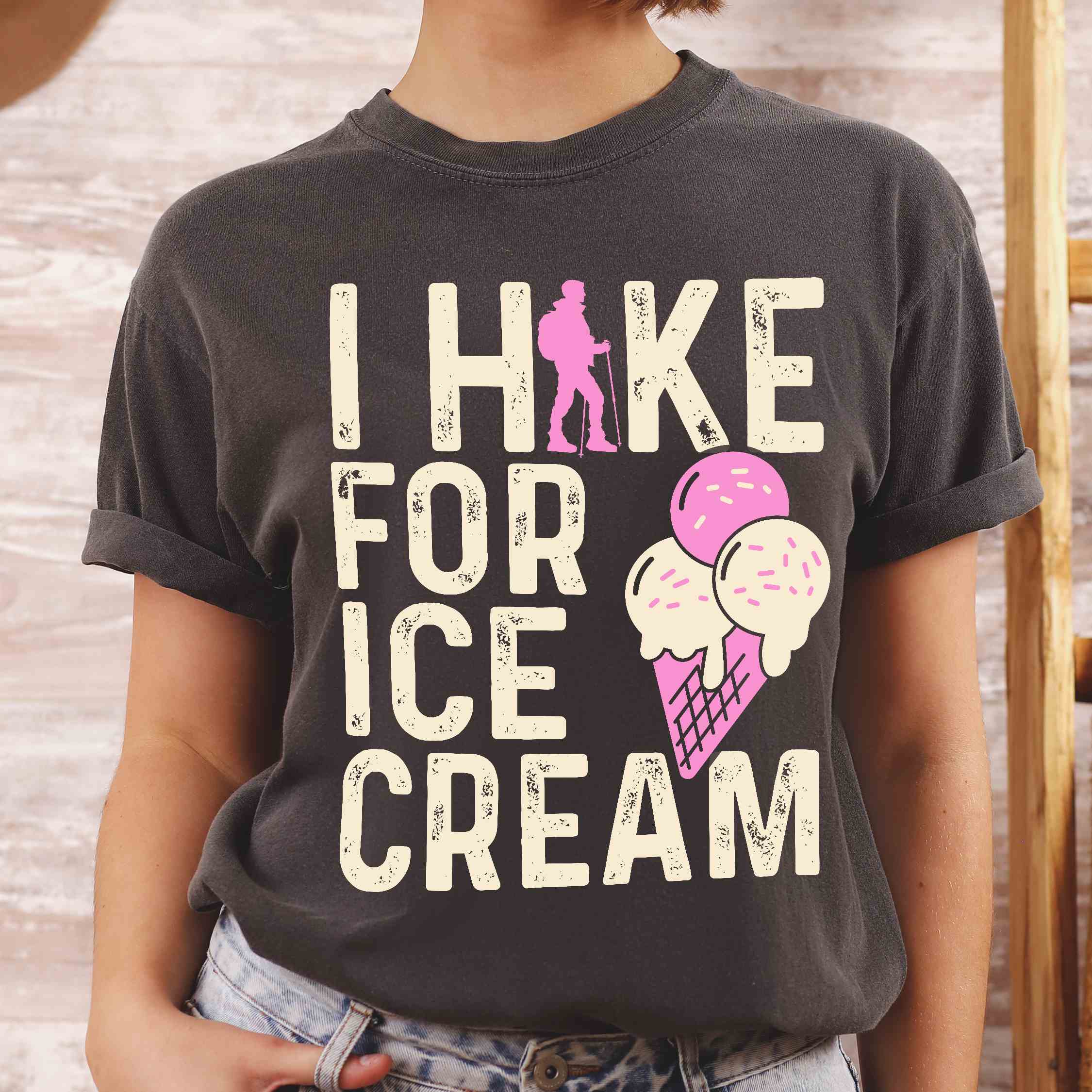 Woman wearing pepper I Hike for Ice Cream statement tee with vintage distressed typography, hiker silhouette, and double-scoop ice cream cone illustration on Comfort Colors shirt for dessert-loving outdoor enthusiasts and hikers