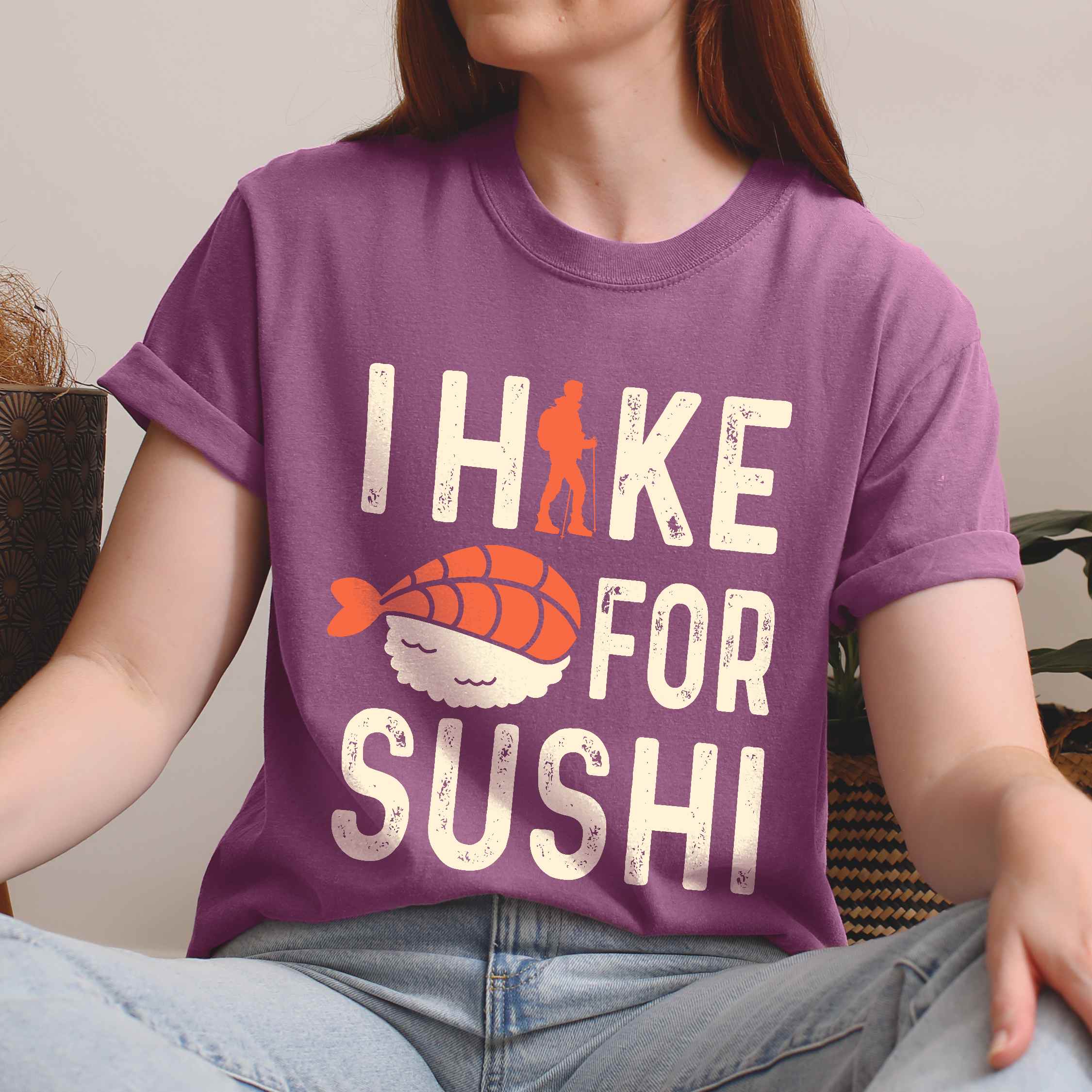 Woman wearing berry 'I Hike for Sushi' text in cream lettering, illustrated shrimp sushi, and backpacker for sushi lovers