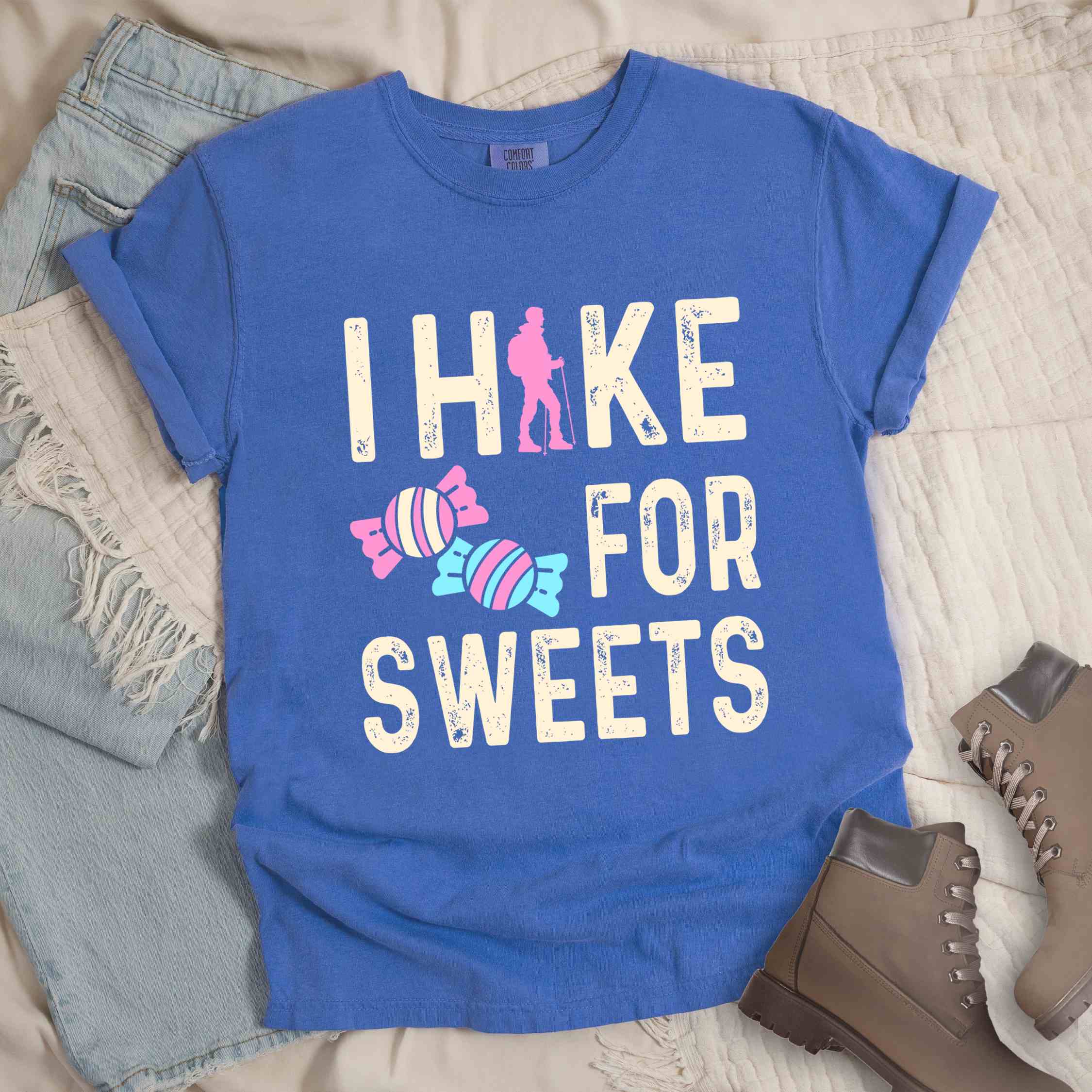 Flo blue 'I Hike for Sweets' text in cream lettering, illustrated pieces of candies, and backpacker for candy lovers