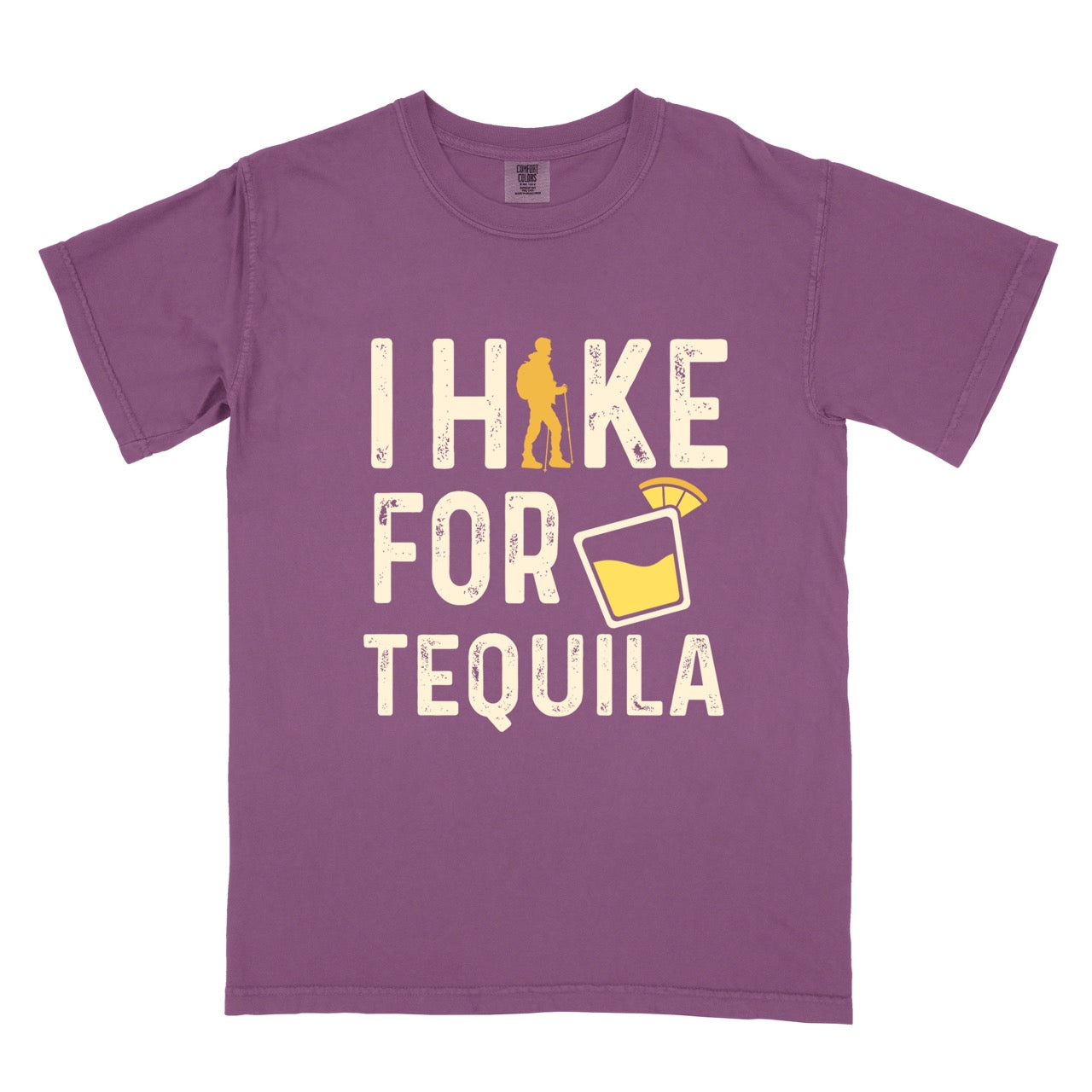 Berry (purple) Tequila margarita lover statement tee I Hike for Tequila with vintage distressed cream typography character silhouette with trekking pole and illustrated tilted margarita glass with lime garnish on Comfort Colors shirt for drink enthusiasts for hikers and foodies.