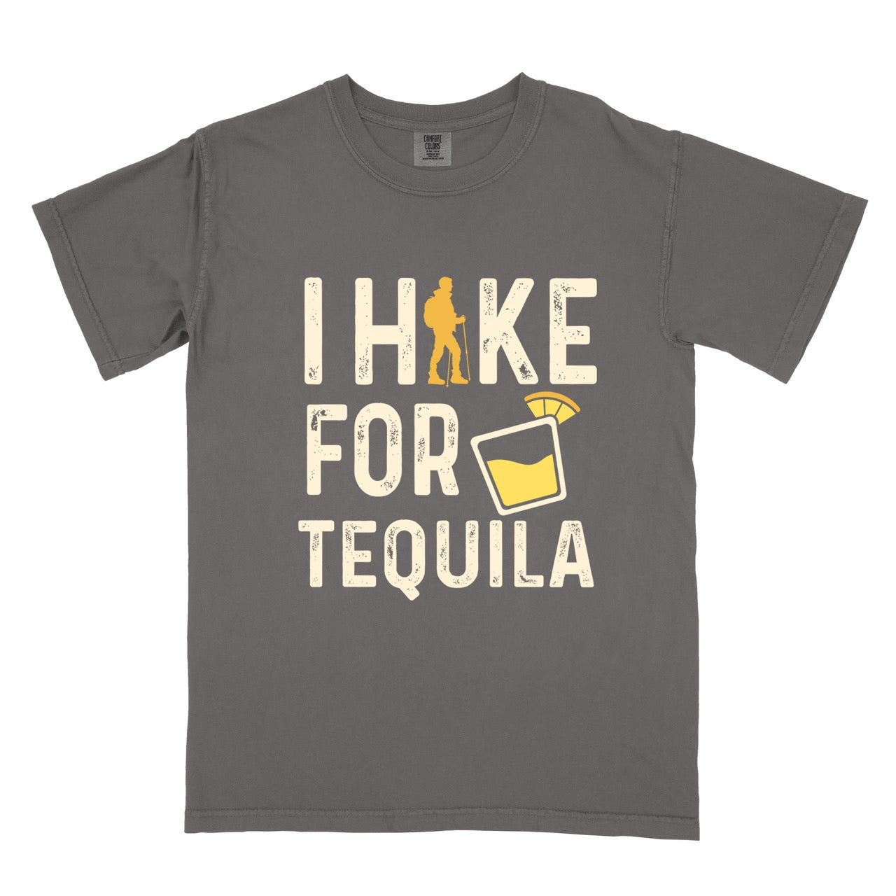 Pepper (Grey) Tequila margarita lover statement tee I Hike for Tequila with vintage distressed cream typography character silhouette with trekking pole and illustrated tilted margarita glass with lime garnish on Comfort Colors shirt for drink enthusiasts for hikers and foodies.