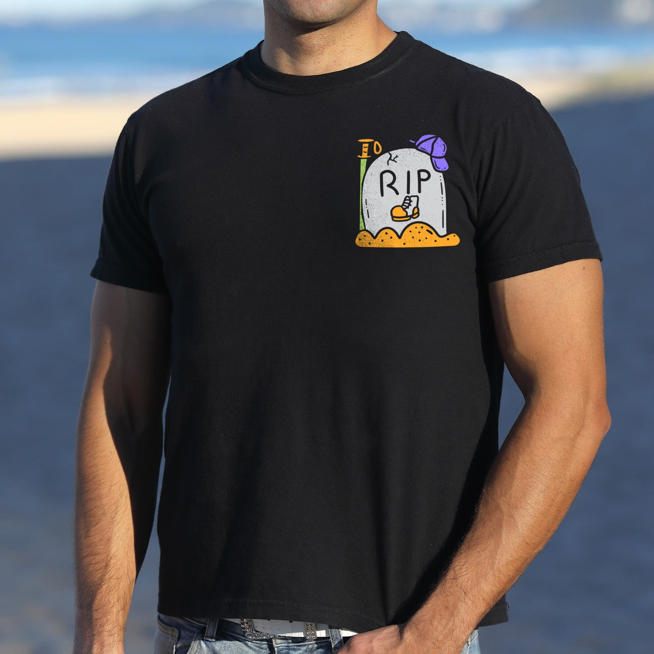 Person wearing a black t-shirt with a graphic design of RIP booth on a blurred outdoor background