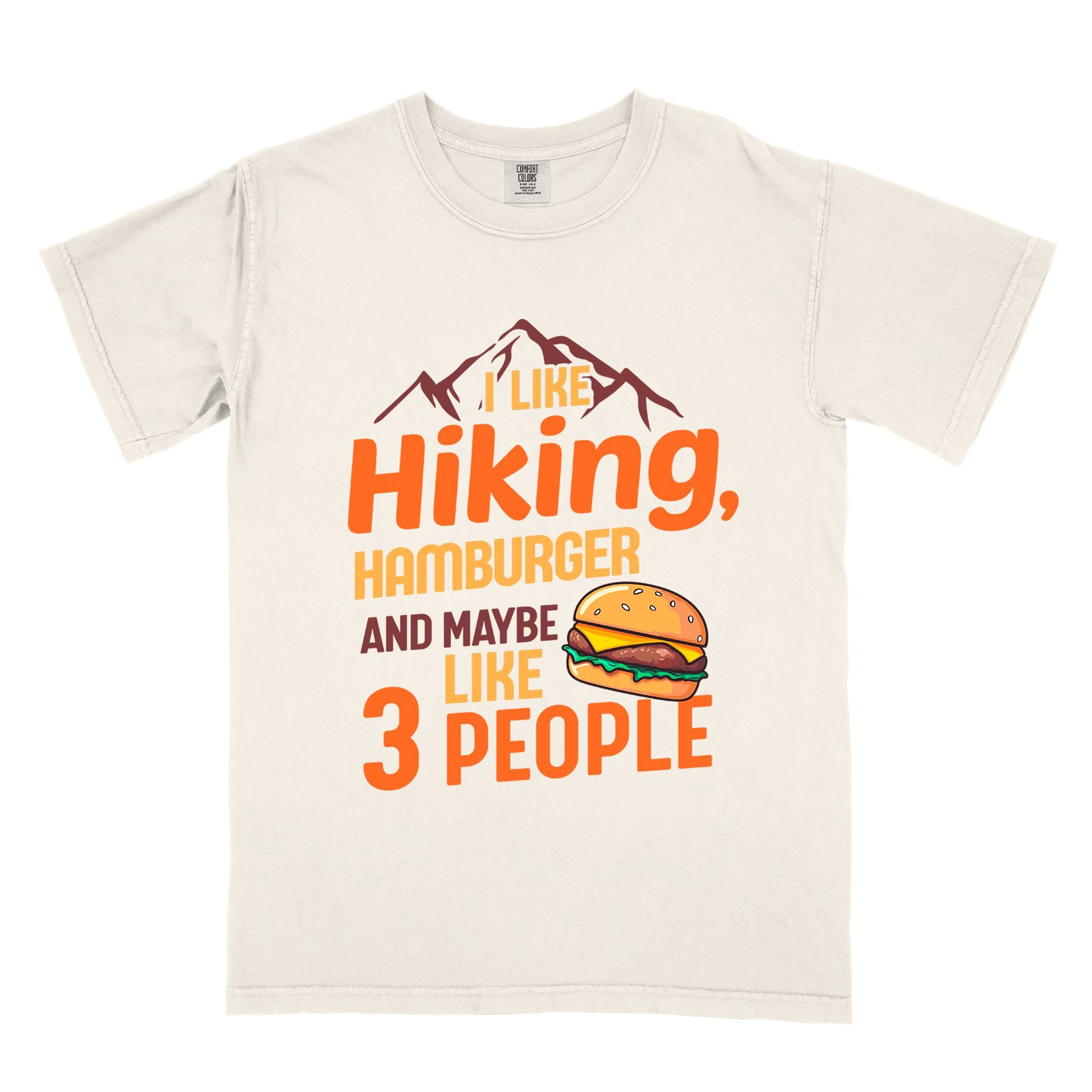 Ivory "I like hiking, hamburger and maybe like three people" colored vintage tee with bold typography, birds, mountains, illustrated juicy hamburger, and backpacker for burger enthusiasts.