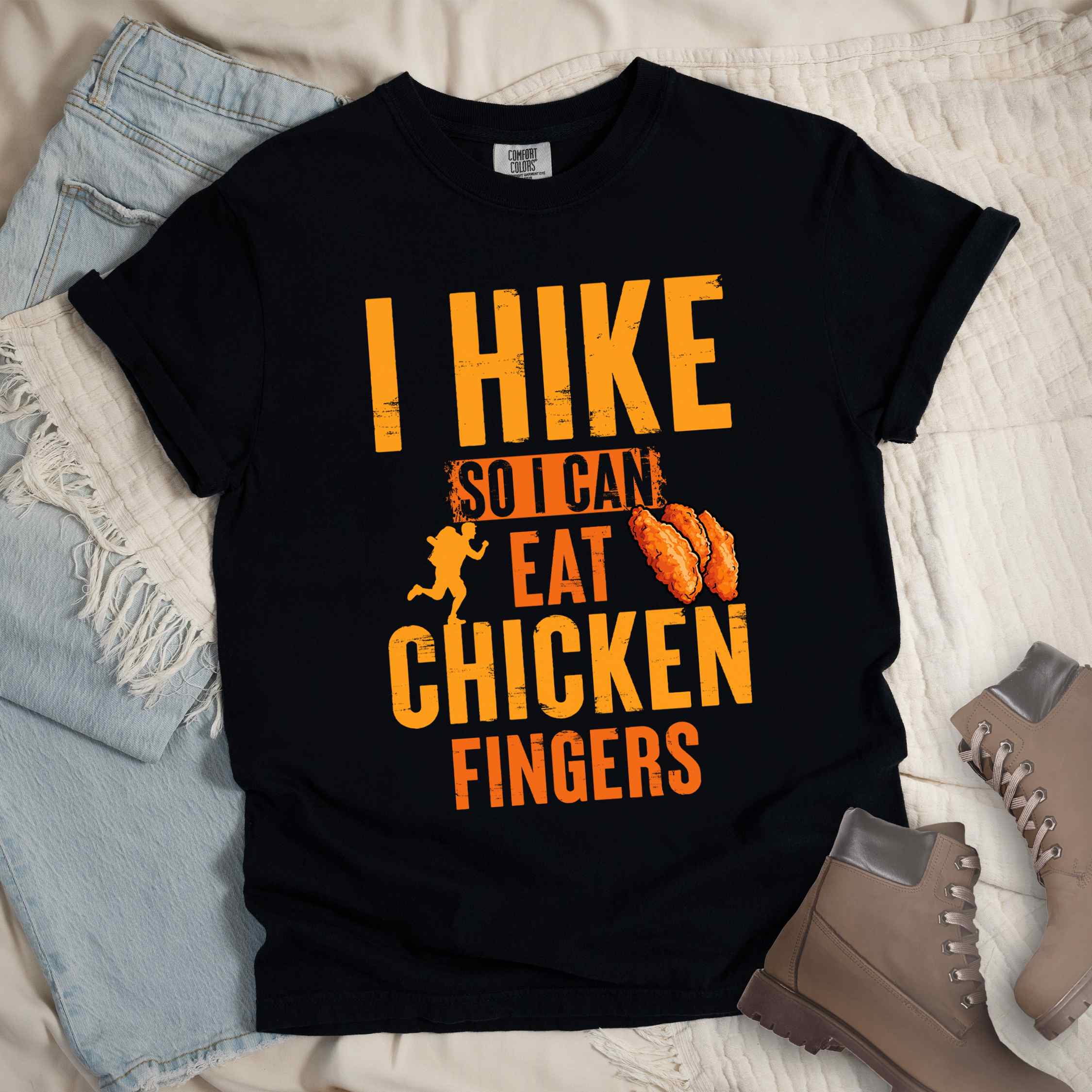 Black "I Hike so I can eat Chicken Fingers" colored vintage tee with bold typography, illustrated crispy fried chicken fingers, perfect for comfort food lovers.
