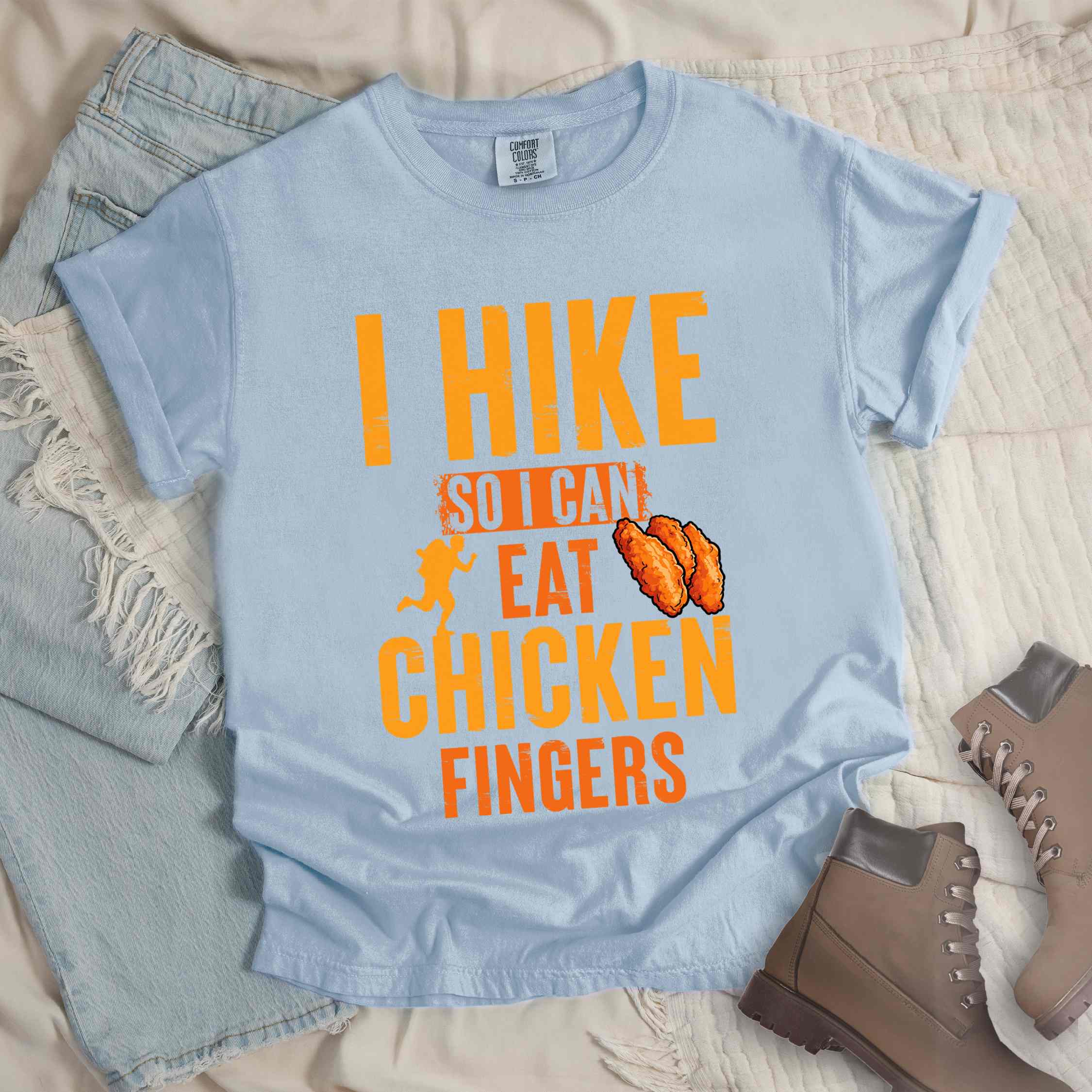 Chambray "I Hike so I can eat Chicken Fingers" colored vintage tee with bold typography, illustrated crispy fried chicken fingers, perfect for comfort food lovers.