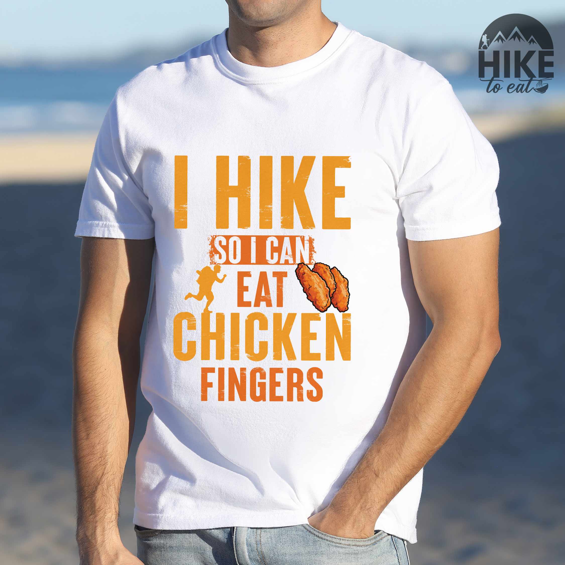 Man wearing white "I Hike so I can eat Chicken Fingers" colored vintage tee with bold typography, illustrated crispy fried chicken fingers, perfect for comfort food lovers.