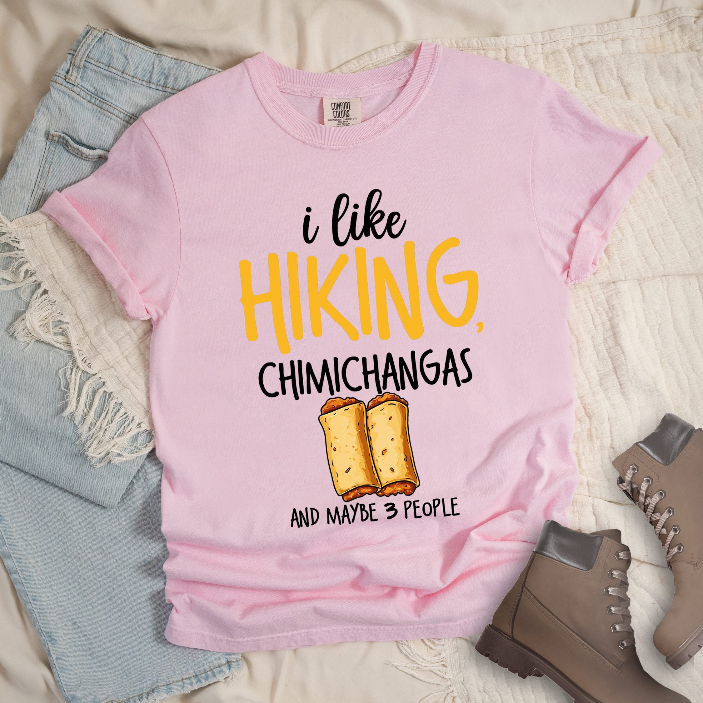 Light pink shirt with Hiking Design featuring the phrase “I Like Hiking, Chimichangas, and Maybe 3 People” with an illustration of two chimichangas below the text.