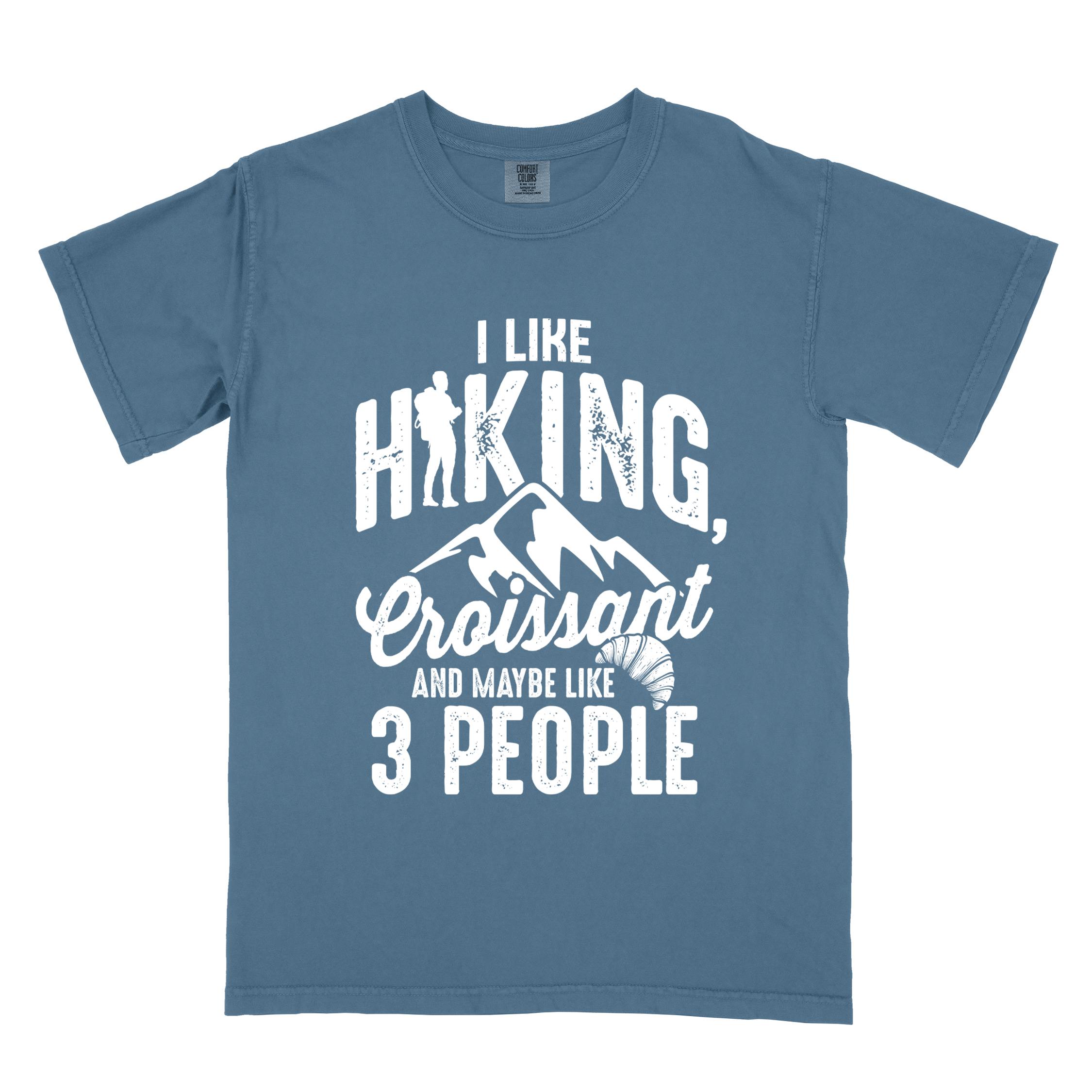 blue jean "I Like hiking, croissant and maybe like 3 people" colored vintage tee with bold typography, birds, mountains, illustrated croissant, and backpacker for pastry enthusiasts.