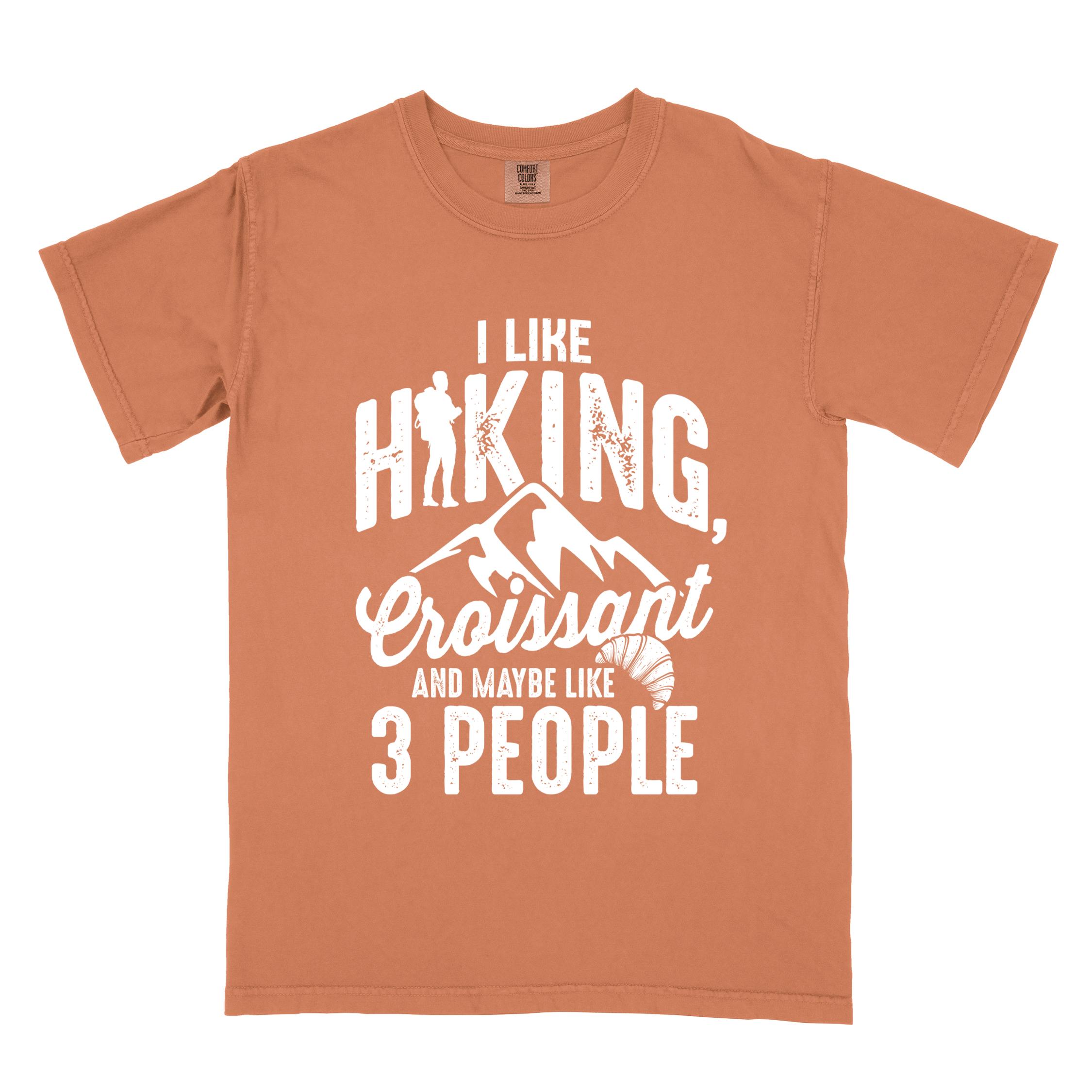 Yam "I Like hiking, croissant and maybe like 3 people" colored vintage tee with bold typography, birds, mountains, illustrated croissant, and backpacker for pastry enthusiasts.