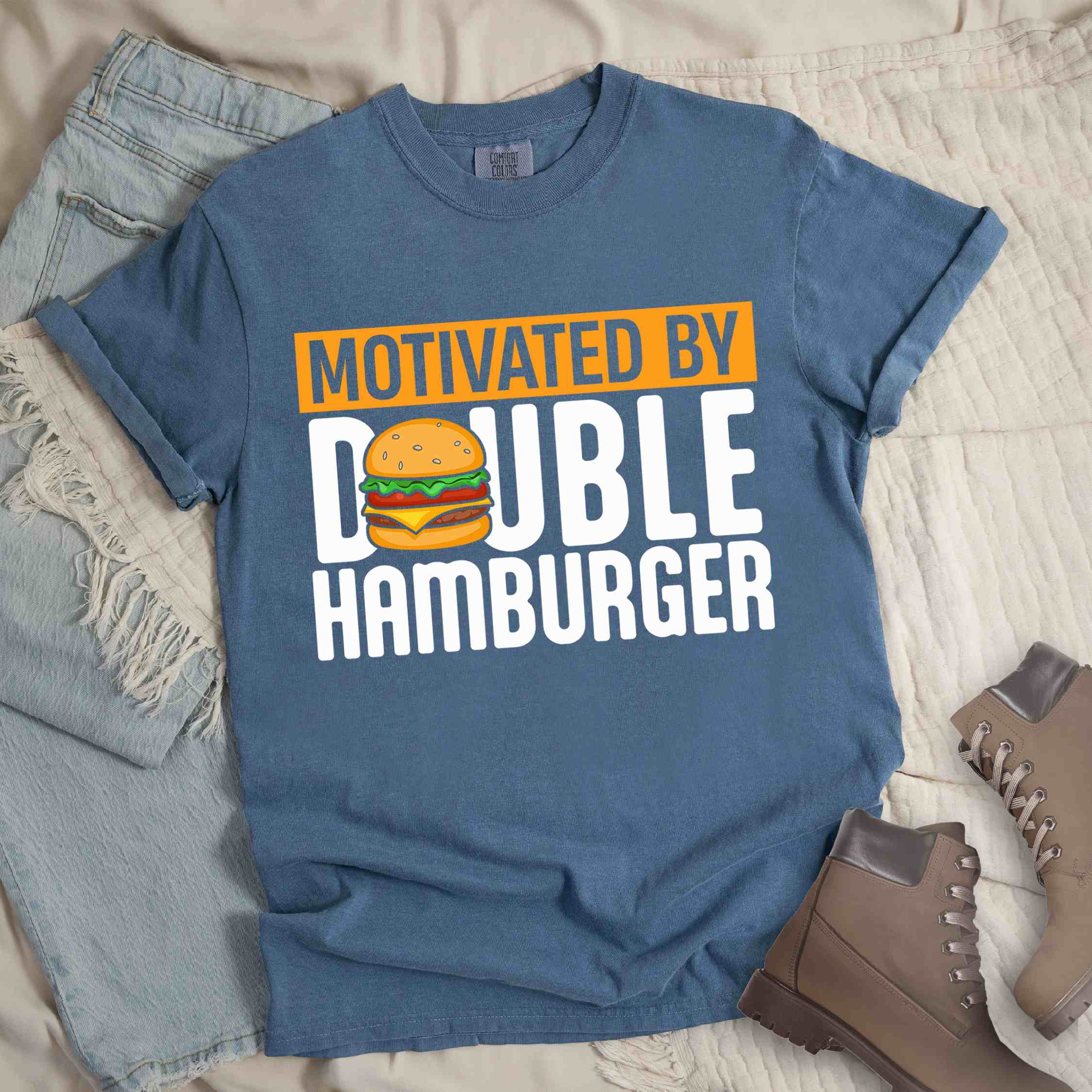 Blue jean "Motivated by Double Hamburger" colored vintage tee with bold typography, illustrated juicy hamburger, and backpacker for burger enthusiasts.