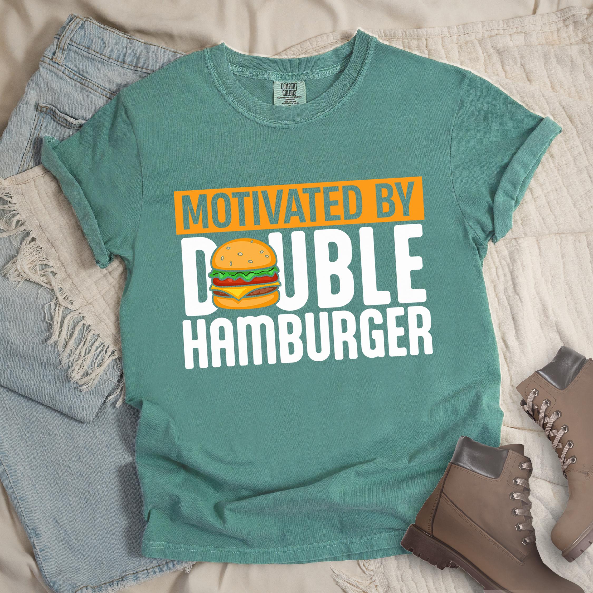 Green shirt with Hiking Design featuring the phrase “Motivated by Double Hamburger” and an illustration of a cartoon-style double hamburger between the words.