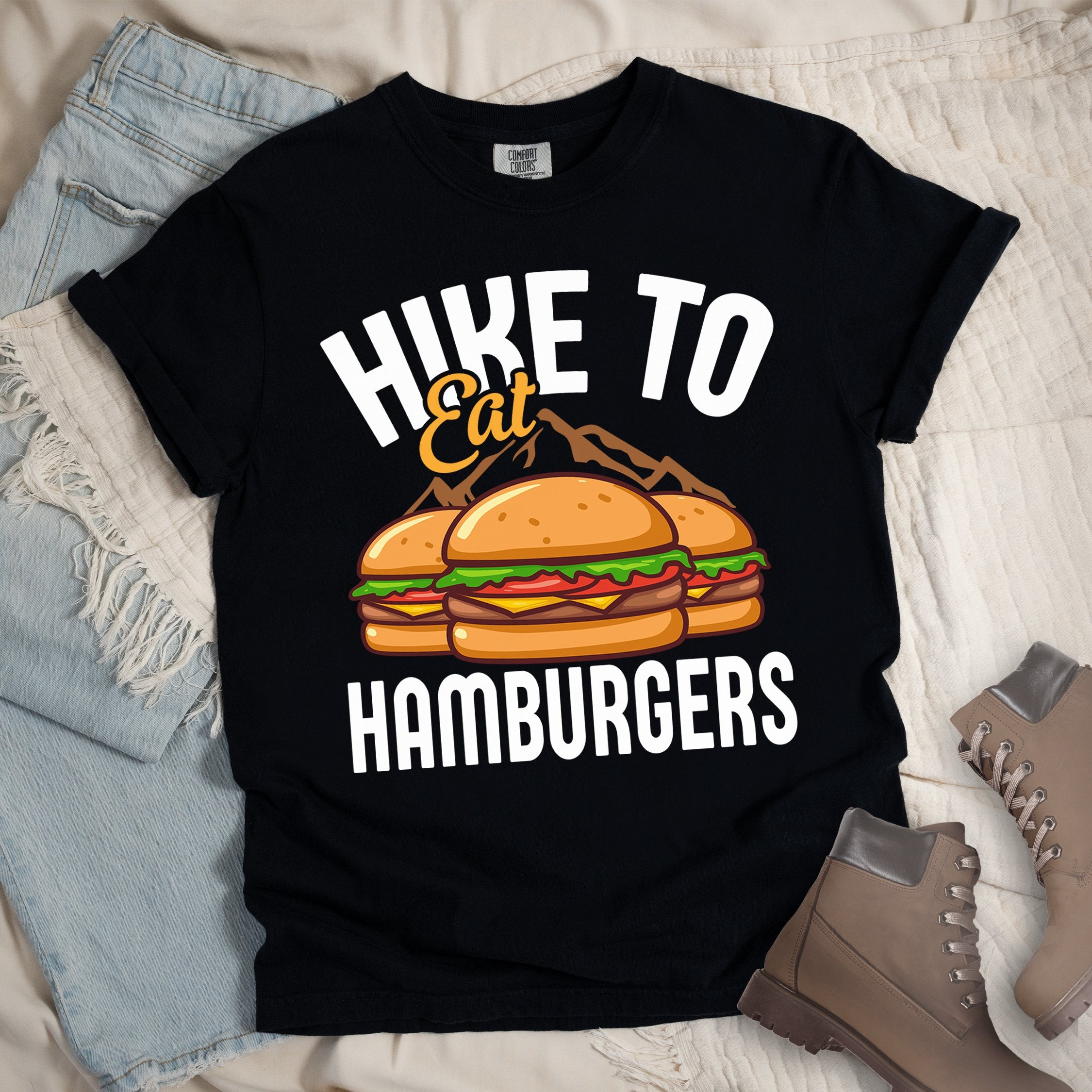 Black shirt with Hiking Design featuring the phrase “Hike to Eat Hamburgers” and an illustration of two hamburgers placed in front of mountain outlines.