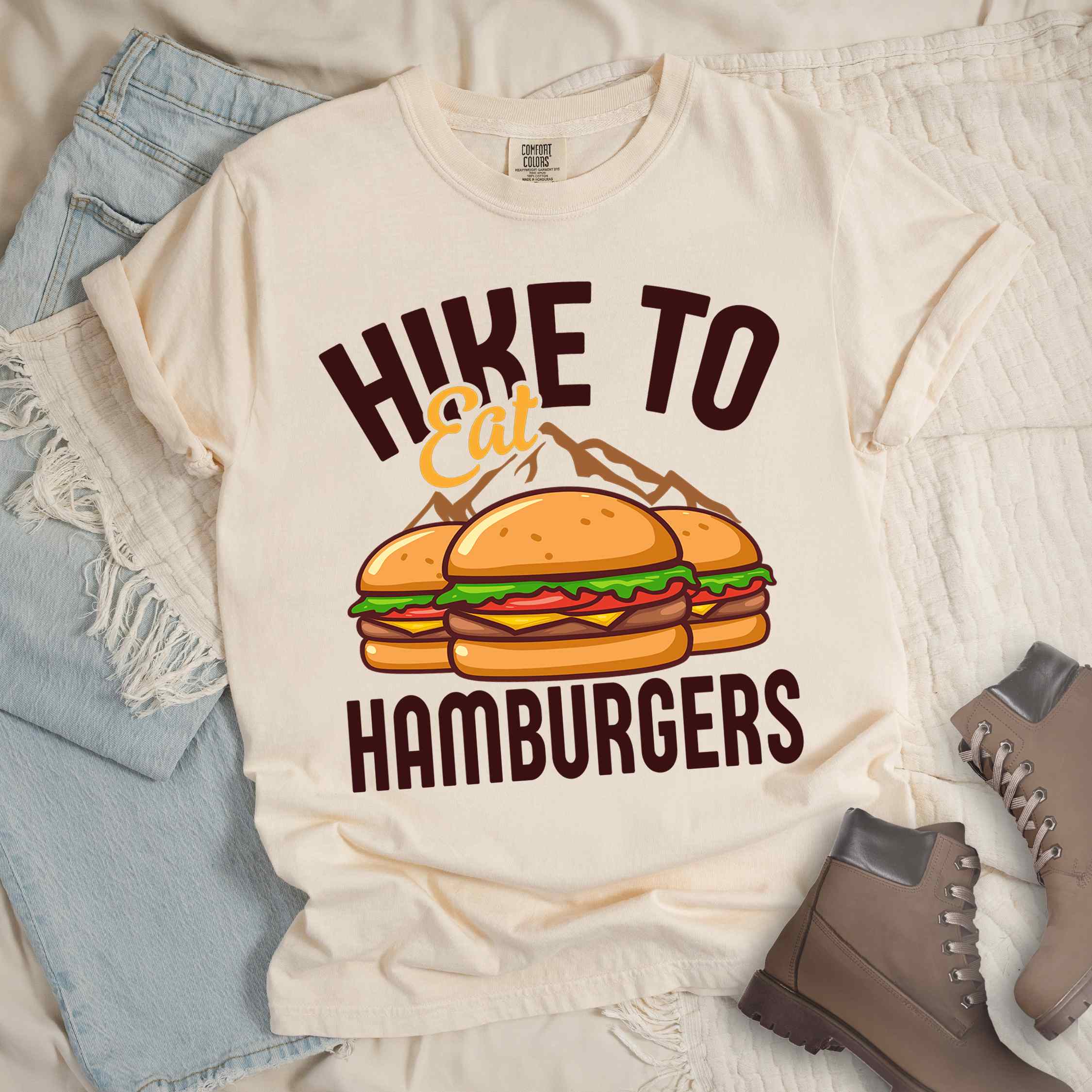 Ivory "Hike to Eat Hamburgers" colored vintage tee with bold typography, illustrated juicy hamburger, and backpacker for burger enthusiasts.