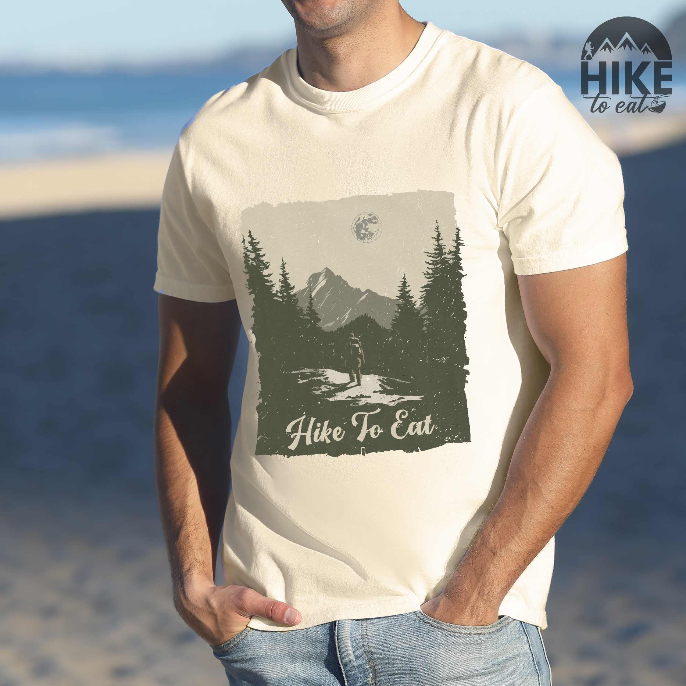 Man wearing ivory "Hike to Eat" colored vintage tee with bold typography, illustrated landscape, and backpacker for burger enthusiasts.