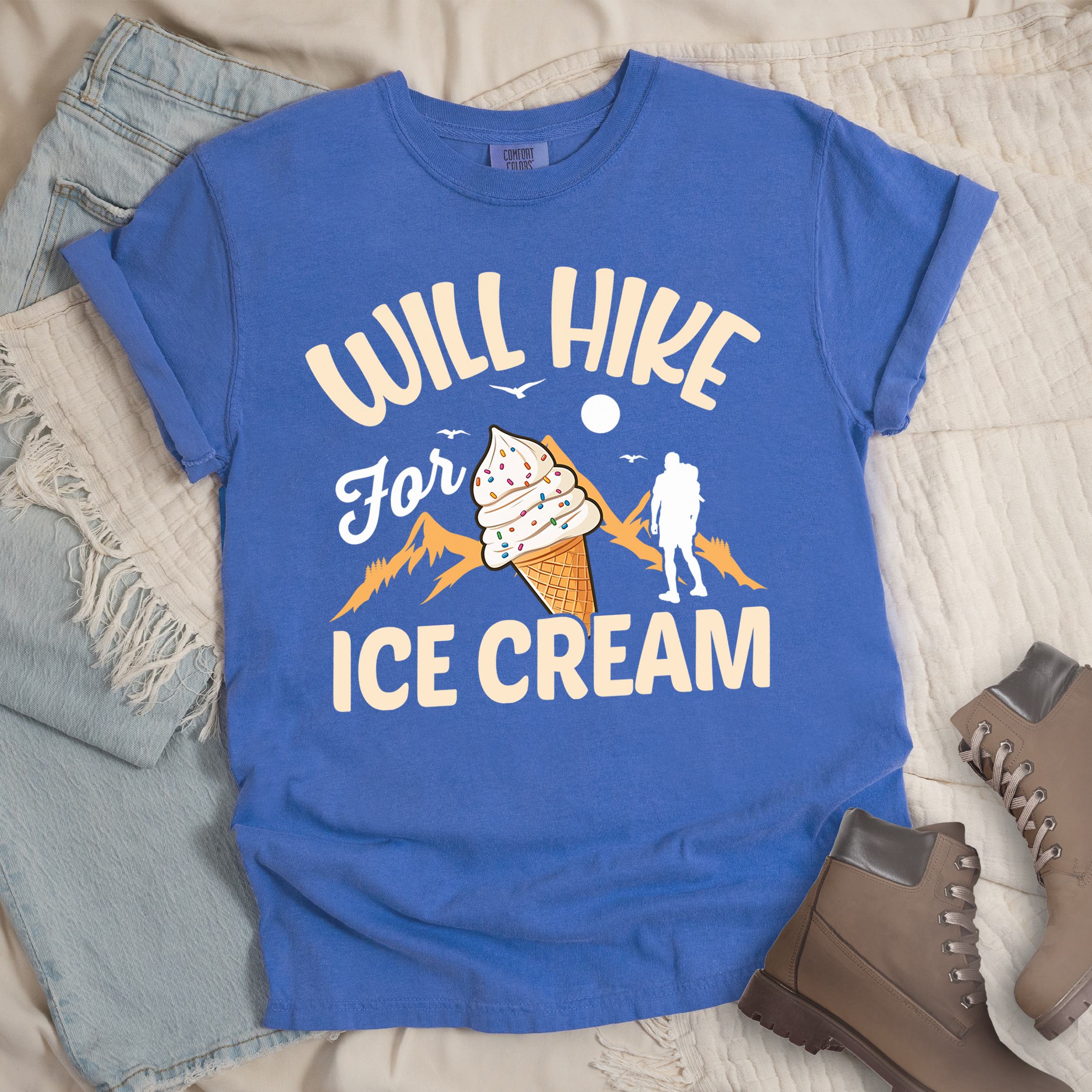 Blue shirt with Hiking Design featuring the phrase “Will Hike for Ice Cream” and an illustration of an ice cream cone with sprinkles below a mountain outline and hiker silhouette.