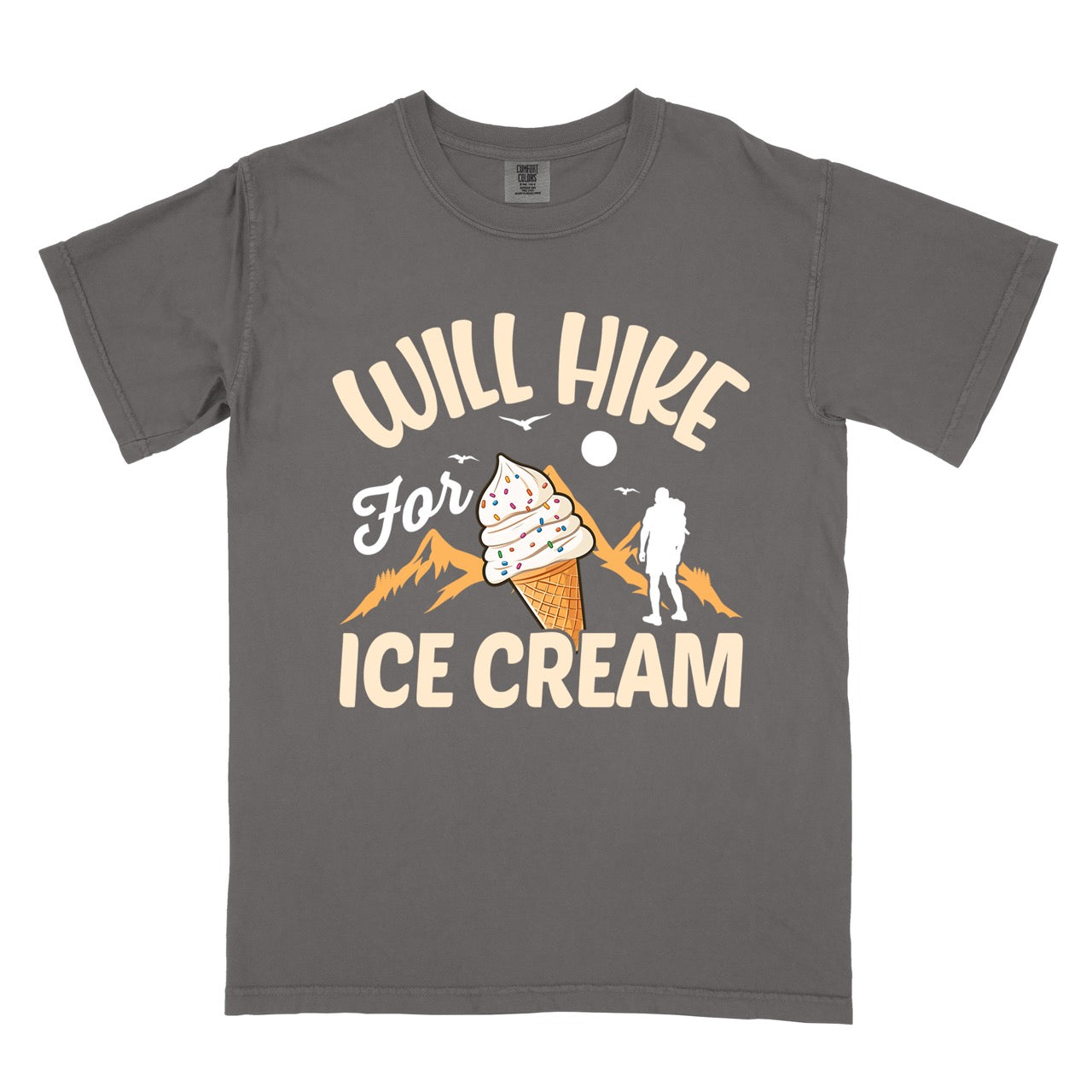 Pepper (grey) Will Hike for Ice Cream statement tee with curved typography, script lettering, mountain peaks, hiker silhouette, and ice cream cone illustration on Comfort Colors shirt for dessert-loving outdoor enthusiasts