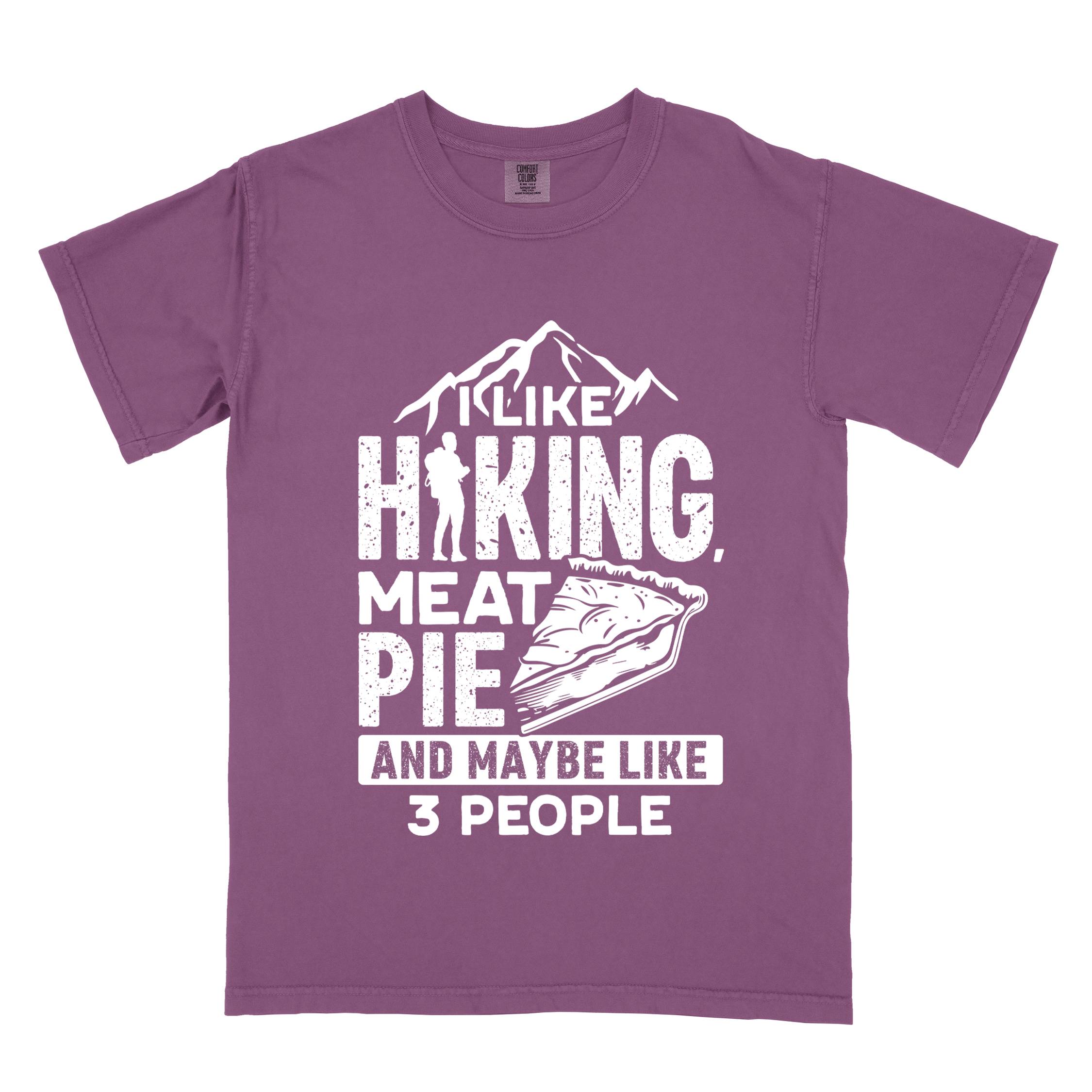 Berry "I like hiking, meat pie and maybe like 3 people" colored vintage tee with bold typography, mountains, birds, illustrated slice of meat pie, and backpacker for pie lovers.
