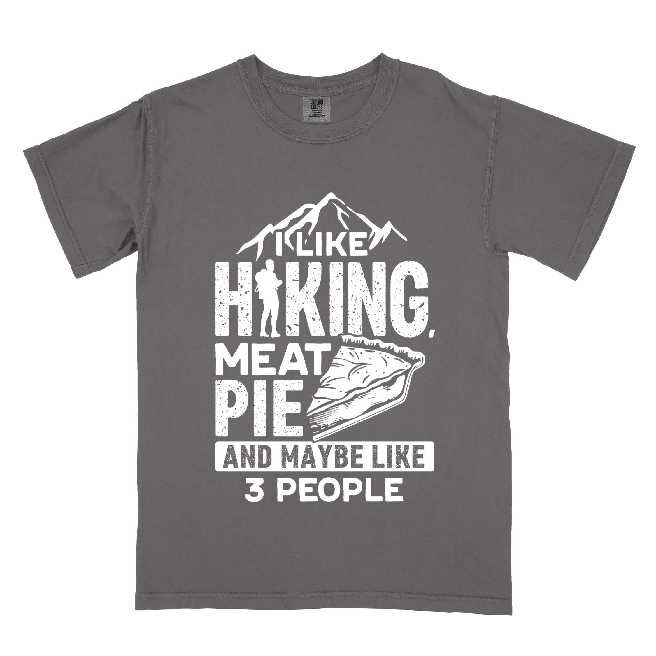 Pepper "I like hiking, meat pie and maybe like 3 people" colored vintage tee with bold typography, mountains, birds, illustrated slice of meat pie, and backpacker for pie lovers.