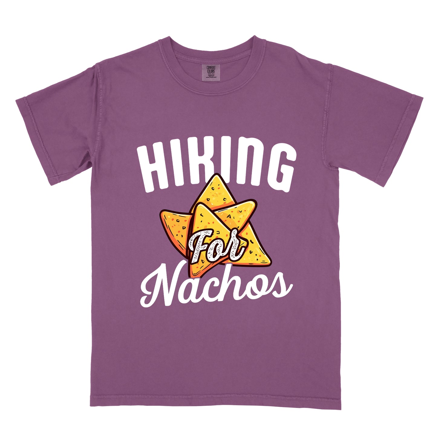 Berry (Dark Violet) t-shirt with white text reading "HIKING For Nachos". "HIKING" appears in large white letters at the top, "For" in white script across the middle, and "Nachos" in white script at the bottom. The centerpiece of the design is an illustration of tortilla chips arranged in a star-like pattern, colored yellow-orange with flecks to represent seasonings. The design connects hiking activity with food motivation.
