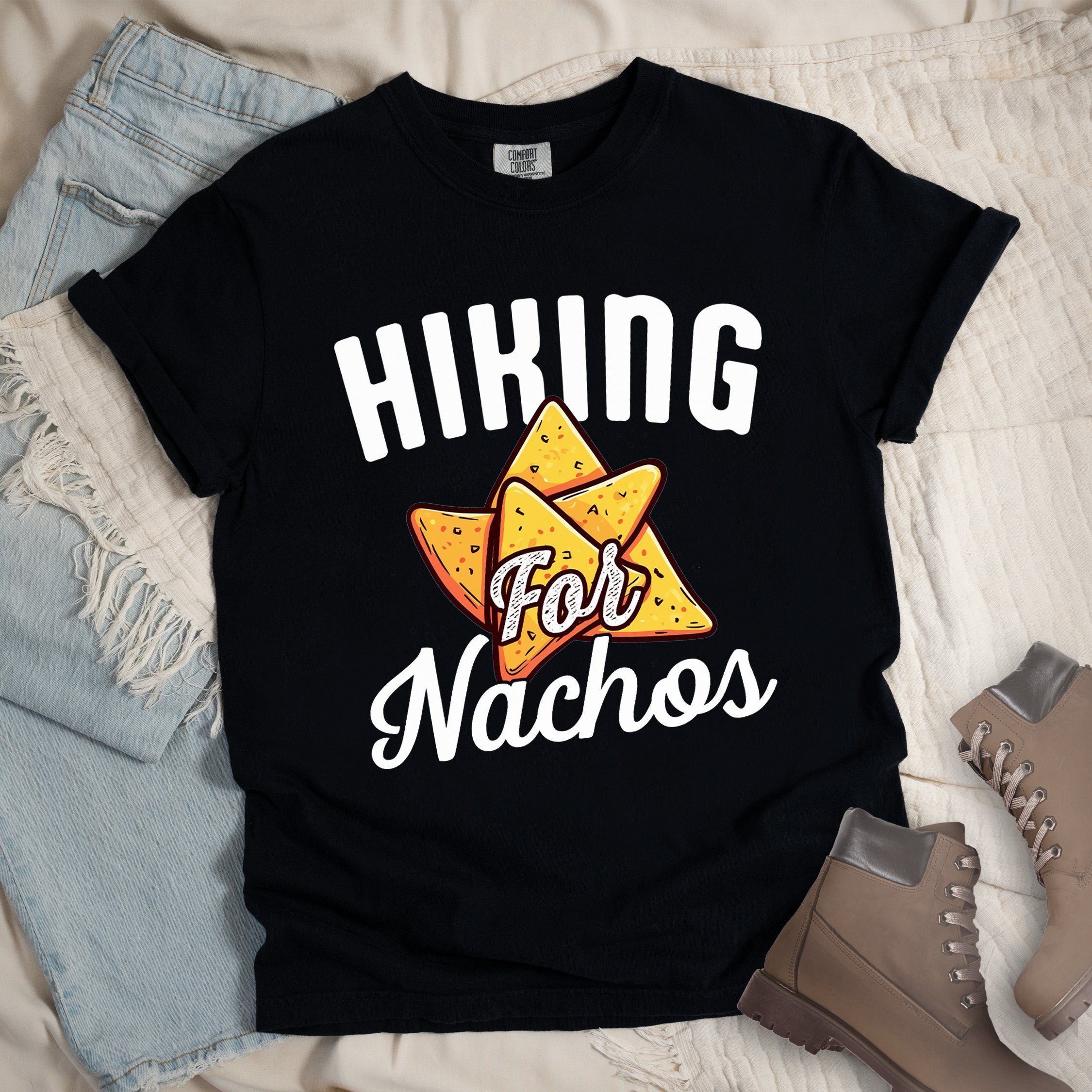 Black shirt with Hiking Design featuring the phrase “Hiking for Nachos” and an illustration of golden nacho chips arranged in a triangle formation.