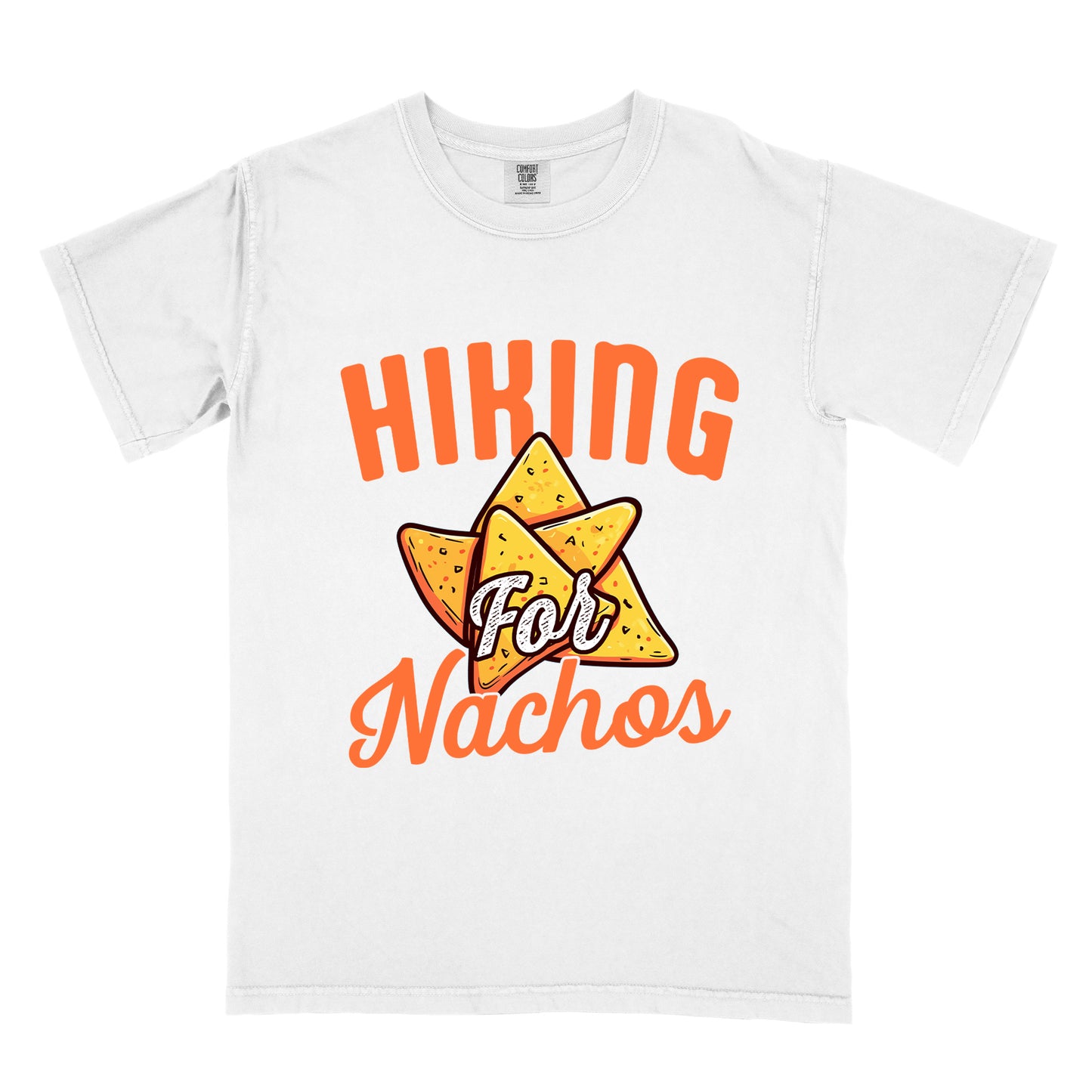 White t-shirt with orange text reading "HIKING For Nachos". "HIKING" appears in large orange letters at the top, "For" in white script across the middle, and "Nachos" in orange script at the bottom. The centerpiece of the design is an illustration of tortilla chips arranged in a star-like pattern, colored yellow-orange with flecks to represent seasonings. The design connects hiking activity with food motivation.
