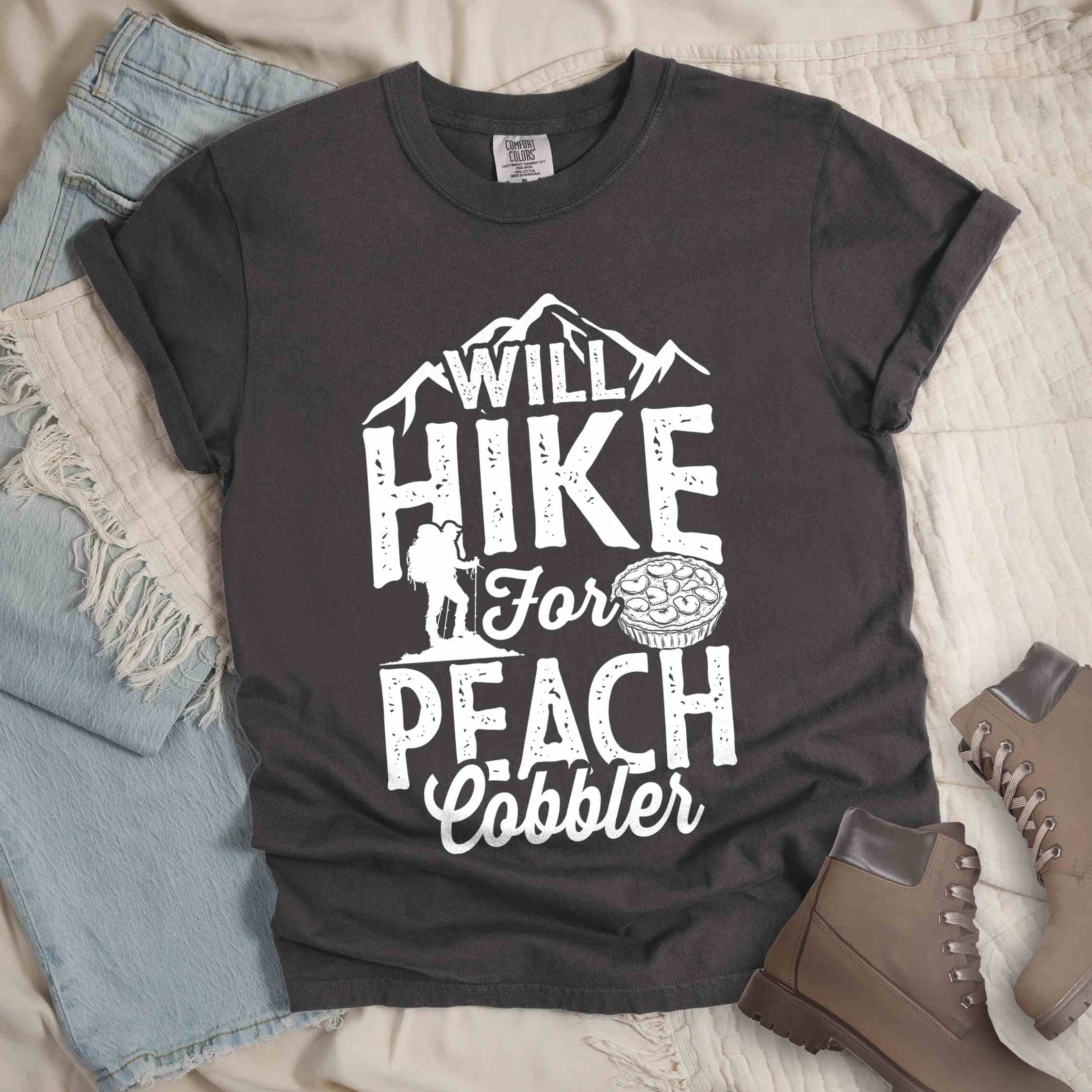 Pepper "Will hike for peach cobbler" colored vintage tee with bold typography, mountain, birds, illustrated peach cobbler, and backpacker looking for sweet treats.