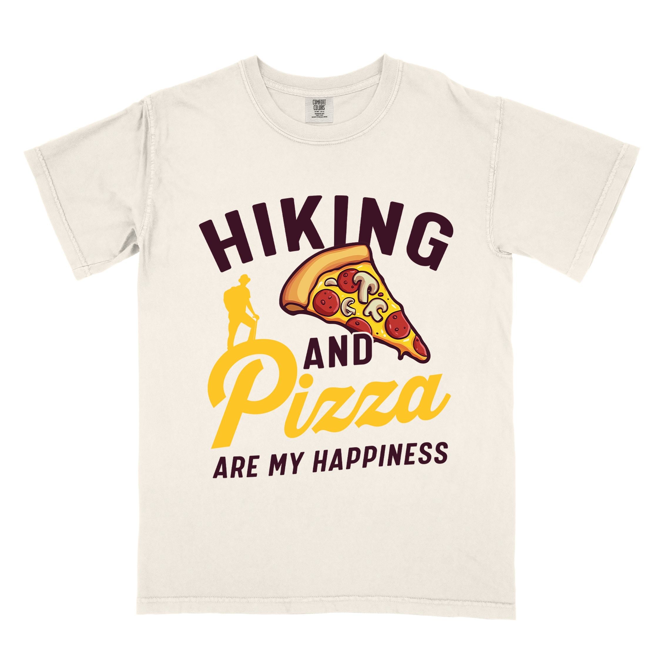 Ivory "Hiking and Pizza are my happiness" colored vintage tee with bold typography, birds, mountains, illustrated pizza slice, and backpacker for pizza lovers.