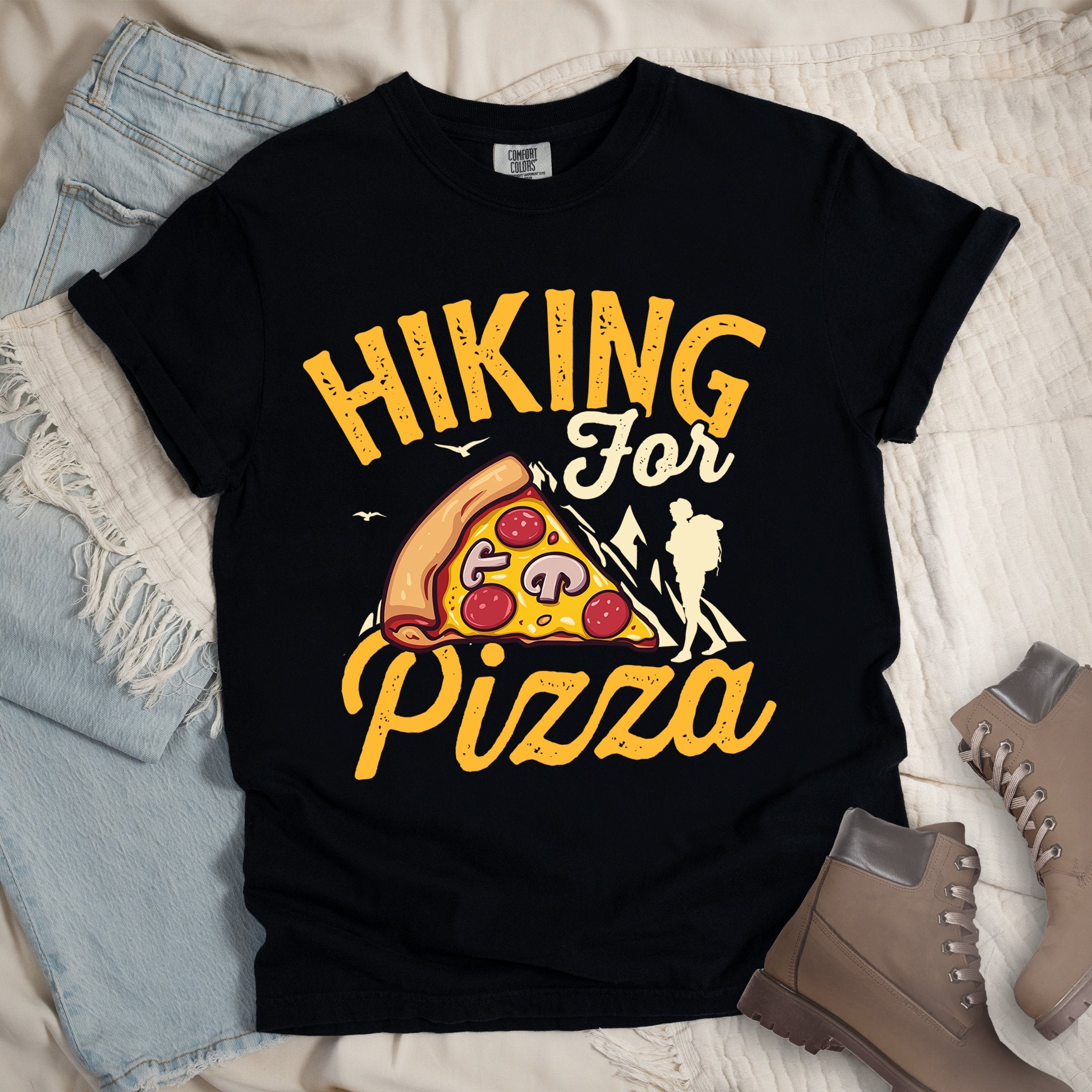 Black shirt with Hiking Design featuring the phrase “Hiking for Pizza” and an illustration of a cheesy pepperoni pizza slice, mountain outline, and hiker silhouette.