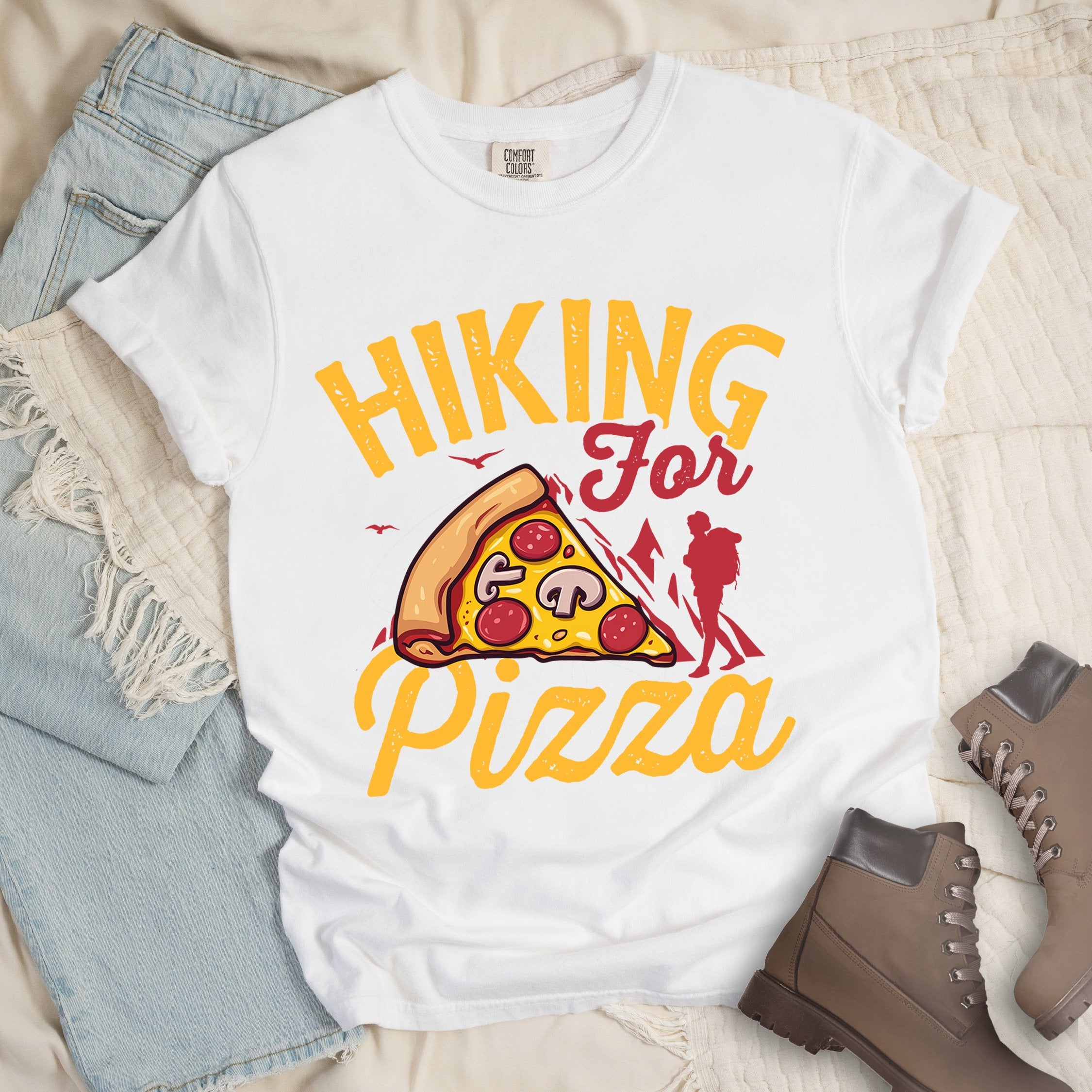 White shirt with Hiking Design featuring the phrase “Hiking for Pizza” and an illustration of a cheesy pepperoni pizza slice, mountain outline, and hiker silhouette.