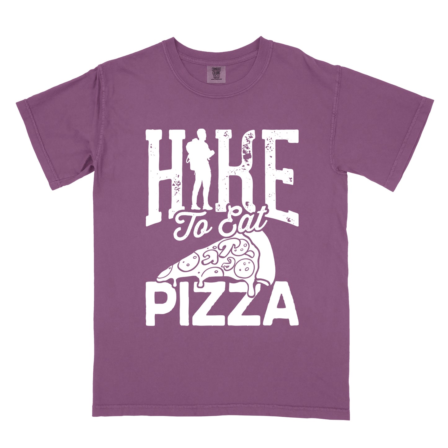 Berry (Dark Violet) t-shirt with white distressed text reading "HIKE To Eat PIZZA". "HIKE" appears in large block letters at the top with a silhouette of a hiker with backpack integrated into the "I", "To Eat" in script in the middle, and "PIZZA" in large block letters at the bottom. Features a simple line drawing of a pizza slice with toppings between the phrases. The design humorously connects hiking activity with pizza as a reward.