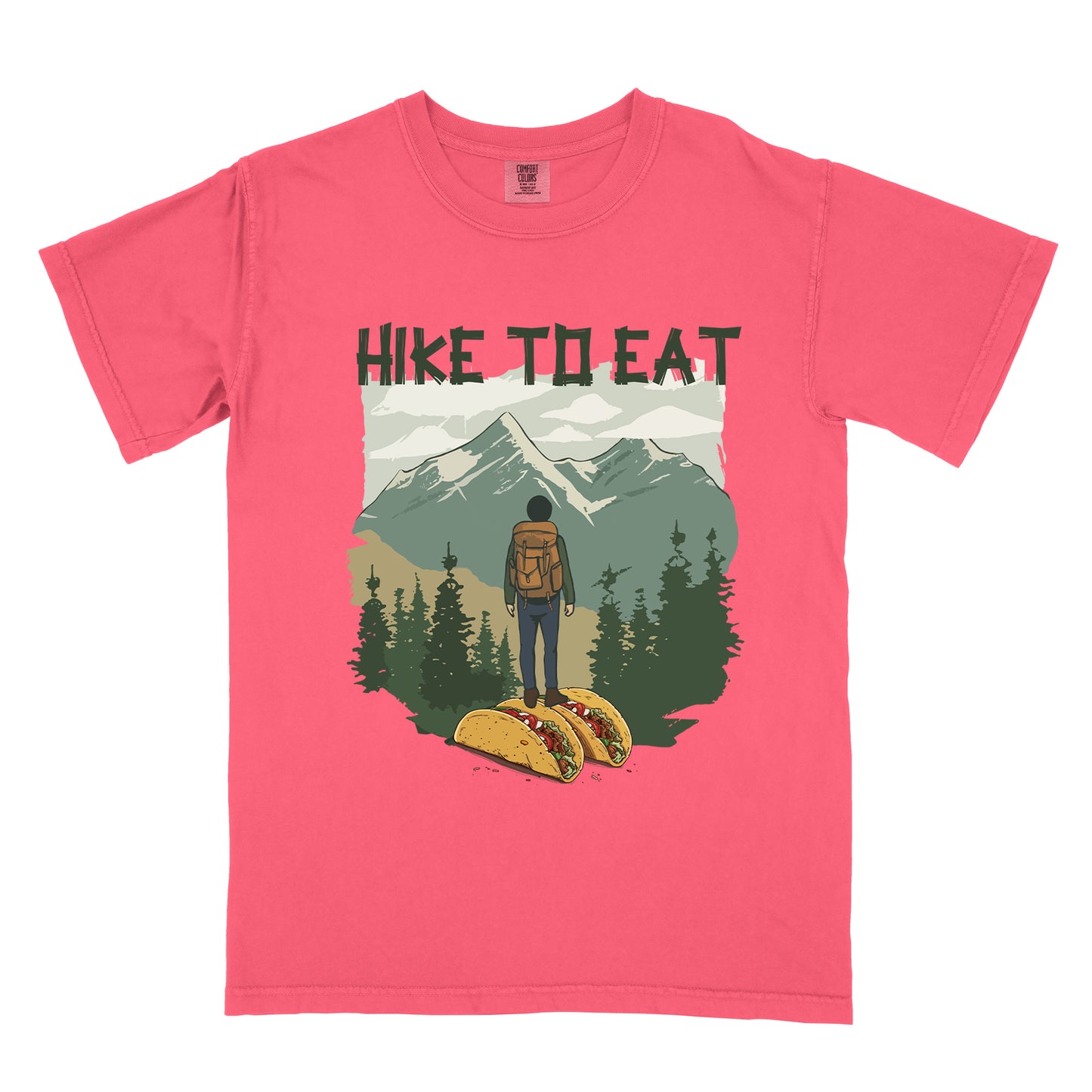 Watermelon (Light coral) t-shirt with "HIKE TO EAT" printed at the top in dark green text. The main graphic shows a hiker with backpack standing on two tacos, facing a scenic mountain landscape with pine trees in the foreground and snow-capped peaks in the background.