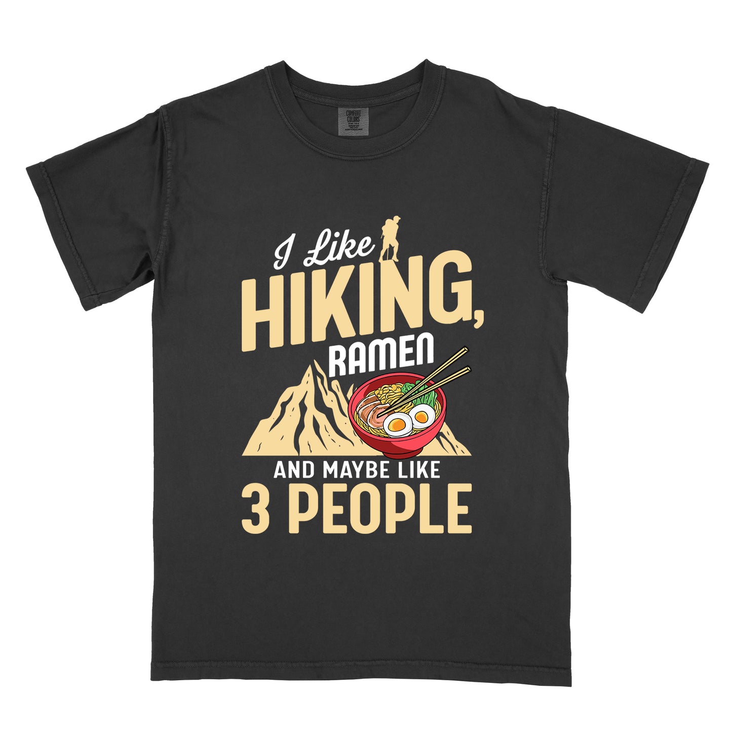 Black t-shirt with mixed text reading "I Like HIKING, RAMEN AND MAYBE LIKE 3 PEOPLE". "I Like" in white script at top with small gold hiker silhouette, "HIKING," in large gold letters, "RAMEN" in white, and "AND MAYBE LIKE 3 PEOPLE" in white and gold. Features a colorful illustration of a red ramen bowl with eggs, noodles and chopsticks, positioned above a gold mountain silhouette.