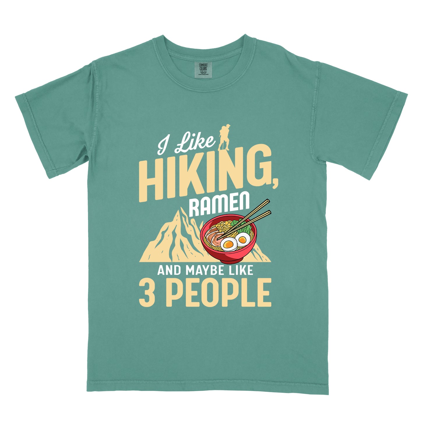 Light Green t-shirt with mixed text reading "I Like HIKING, RAMEN AND MAYBE LIKE 3 PEOPLE". "I Like" in white script at top with small gold hiker silhouette, "HIKING," in large gold letters, "RAMEN" in white, and "AND MAYBE LIKE 3 PEOPLE" in white and gold. Features a colorful illustration of a red ramen bowl with eggs, noodles and chopsticks, positioned above a gold mountain silhouette.