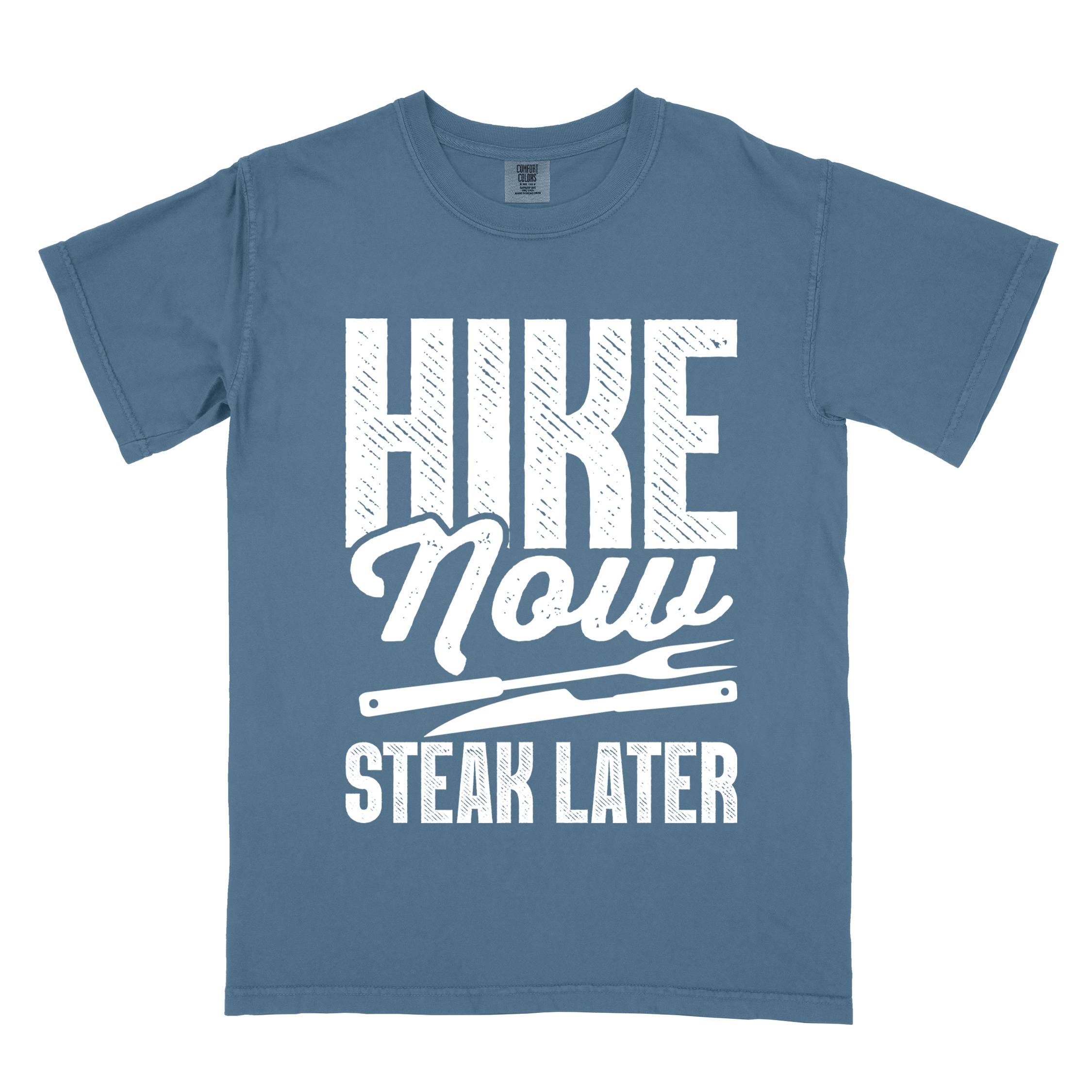 blue jean "Hike now steak later" colored vintage tee with bold typography, illustrated steak utensils, and backpacker for steak lovers.